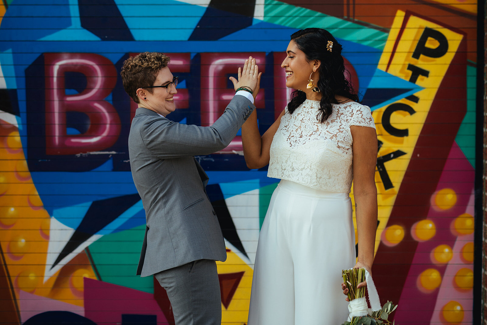 LGBTQ couple highfiving before getting married in Brooklyn NY Shawnee Custalow Queer Wedding Photographer