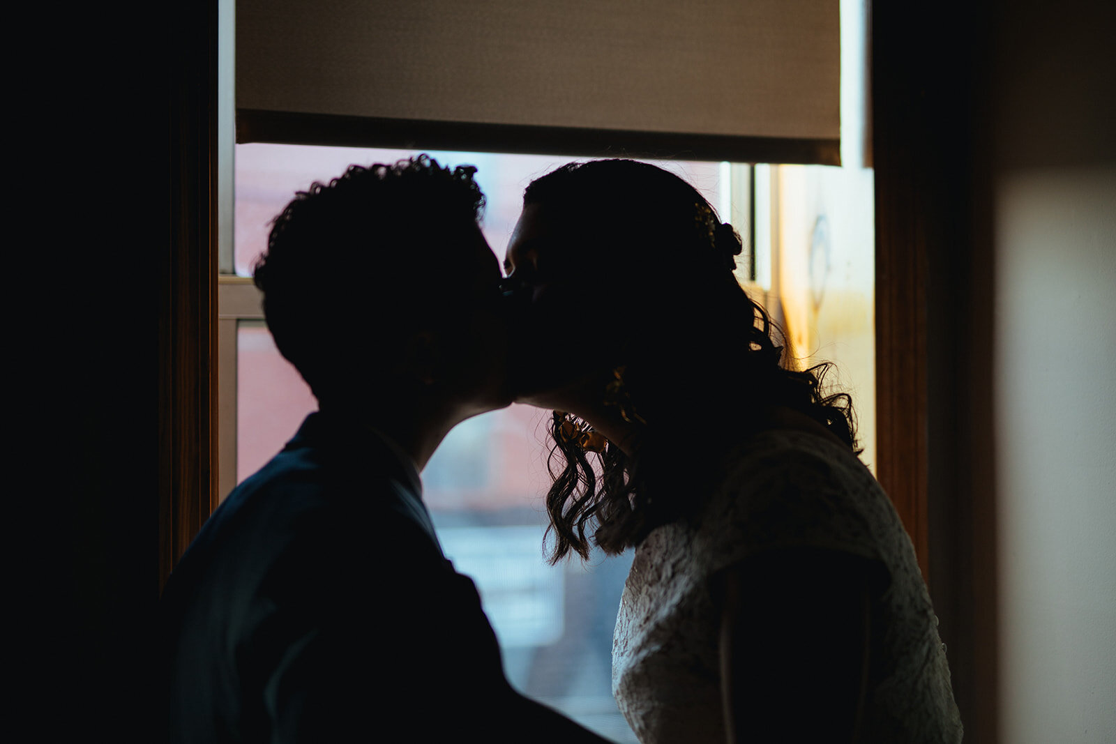 Silhouette of queer wedding couple kissing in Red Hook Brooklyn Shawnee Custalow Queer Wedding Photographer
