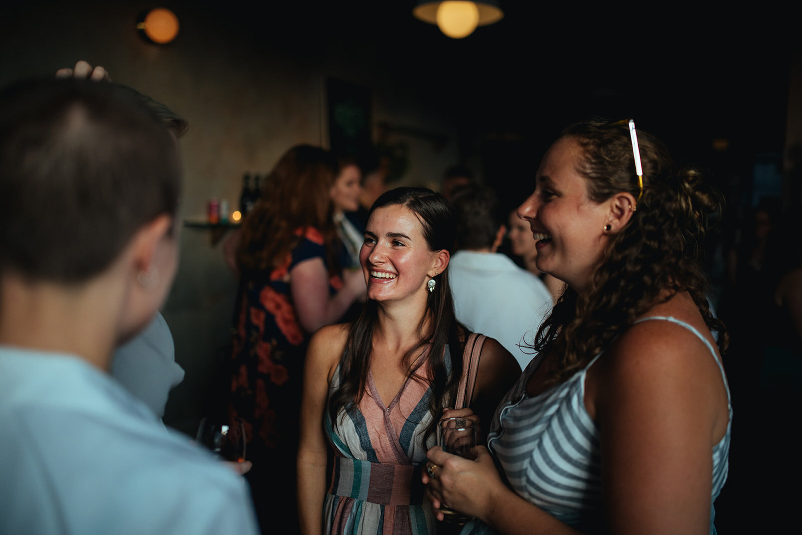 Wedding guests smiling at Marlow Events Red Hook Brooklyn Shawnee Custalow Queer Wedding Photographer