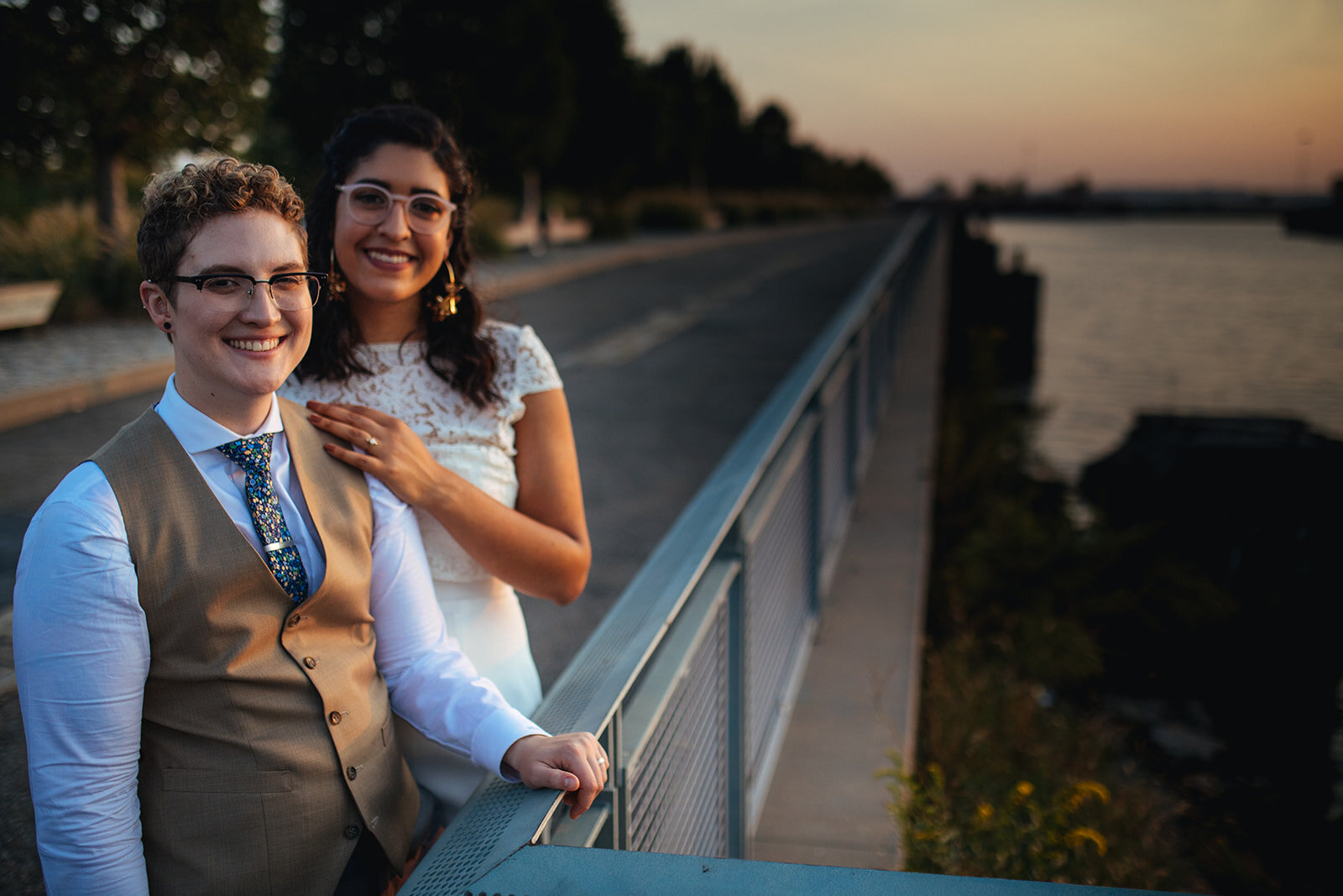 Newlywed LGBTQ couple posing together by water in Red Hook Brooklyn Shawnee Custalow Queer Wedding Photographer