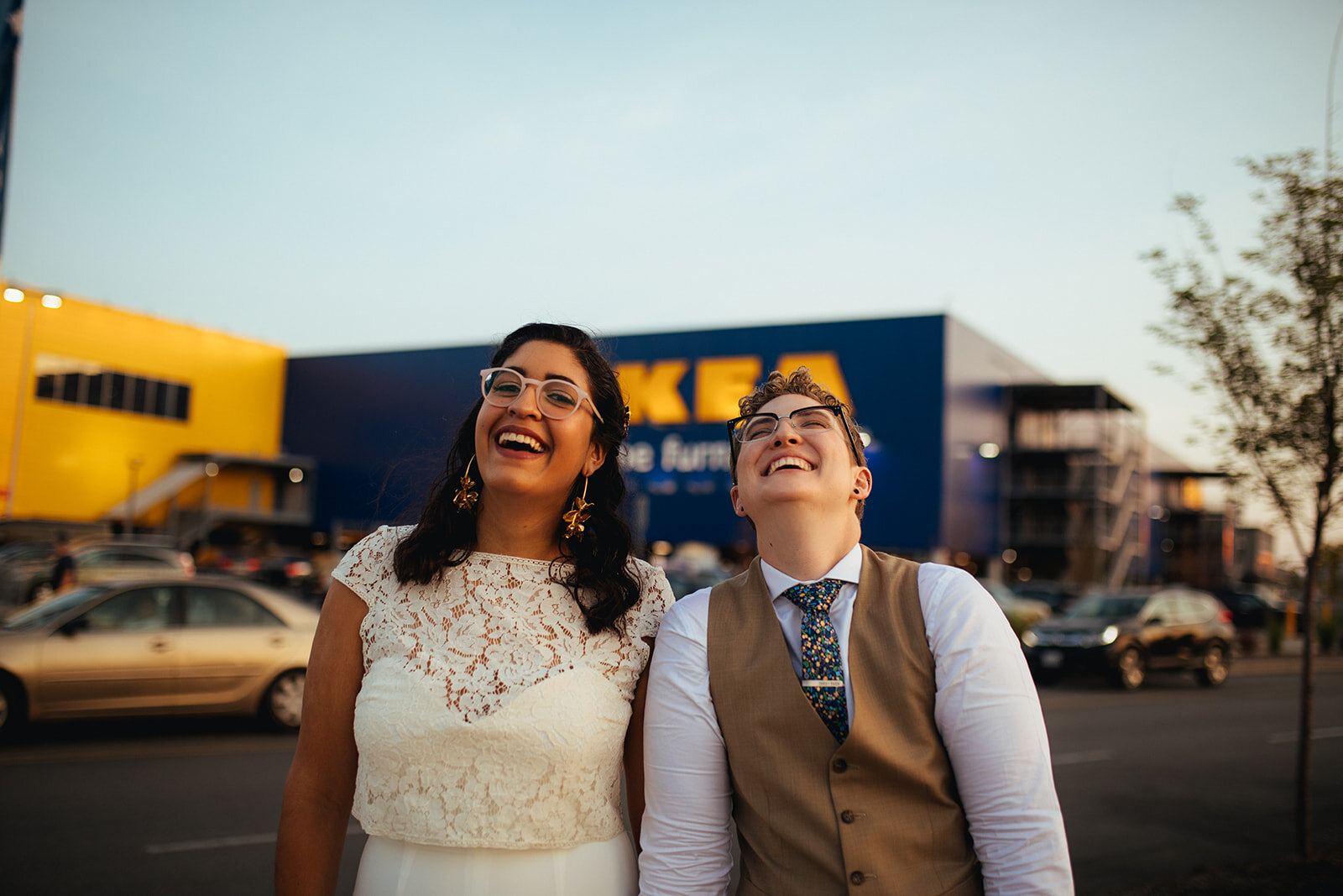 Newlywed LGBTQ couple laughing by Ikea in Red Hook Brooklyn Shawnee Custalow Queer Wedding Photographer