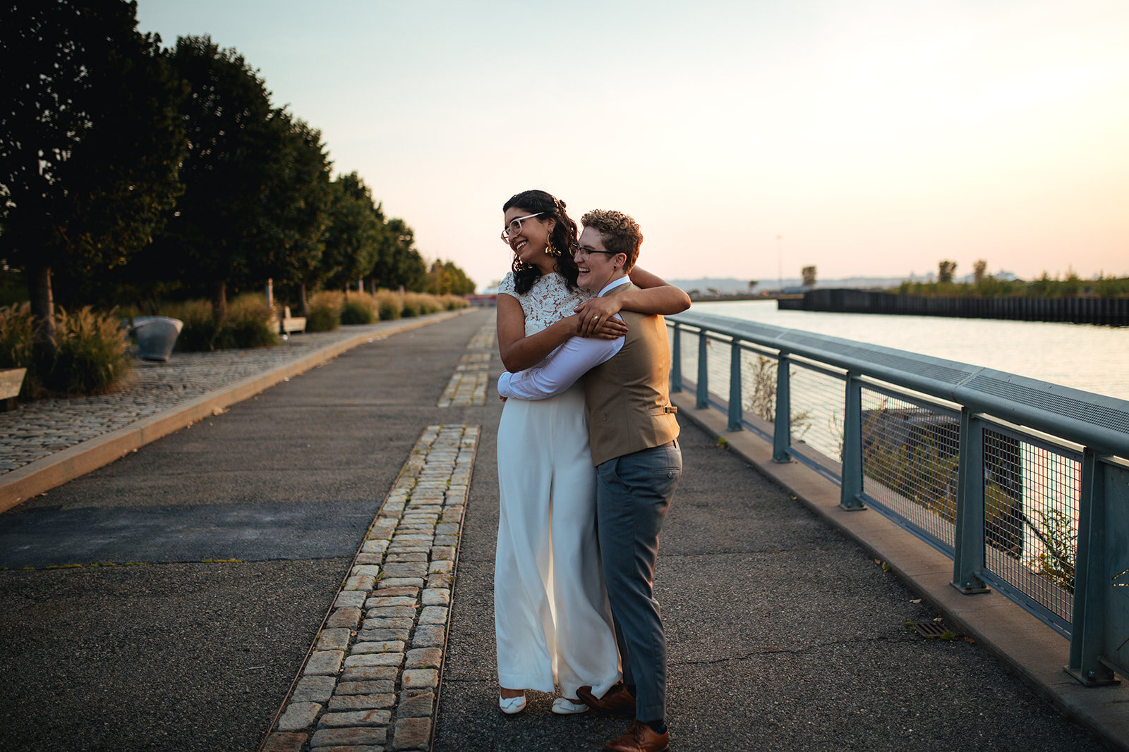 Newlywed LGBTQ couple together on a road by water in Red Hook Brooklyn Shawnee Custalow Queer Wedding Photographer