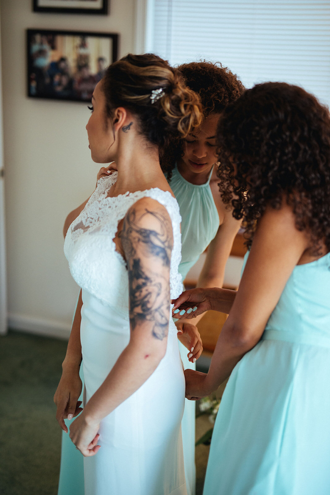 Bridesmaids helping bride into her wedding dress in Annapolis MD Shawnee Custalow Photography