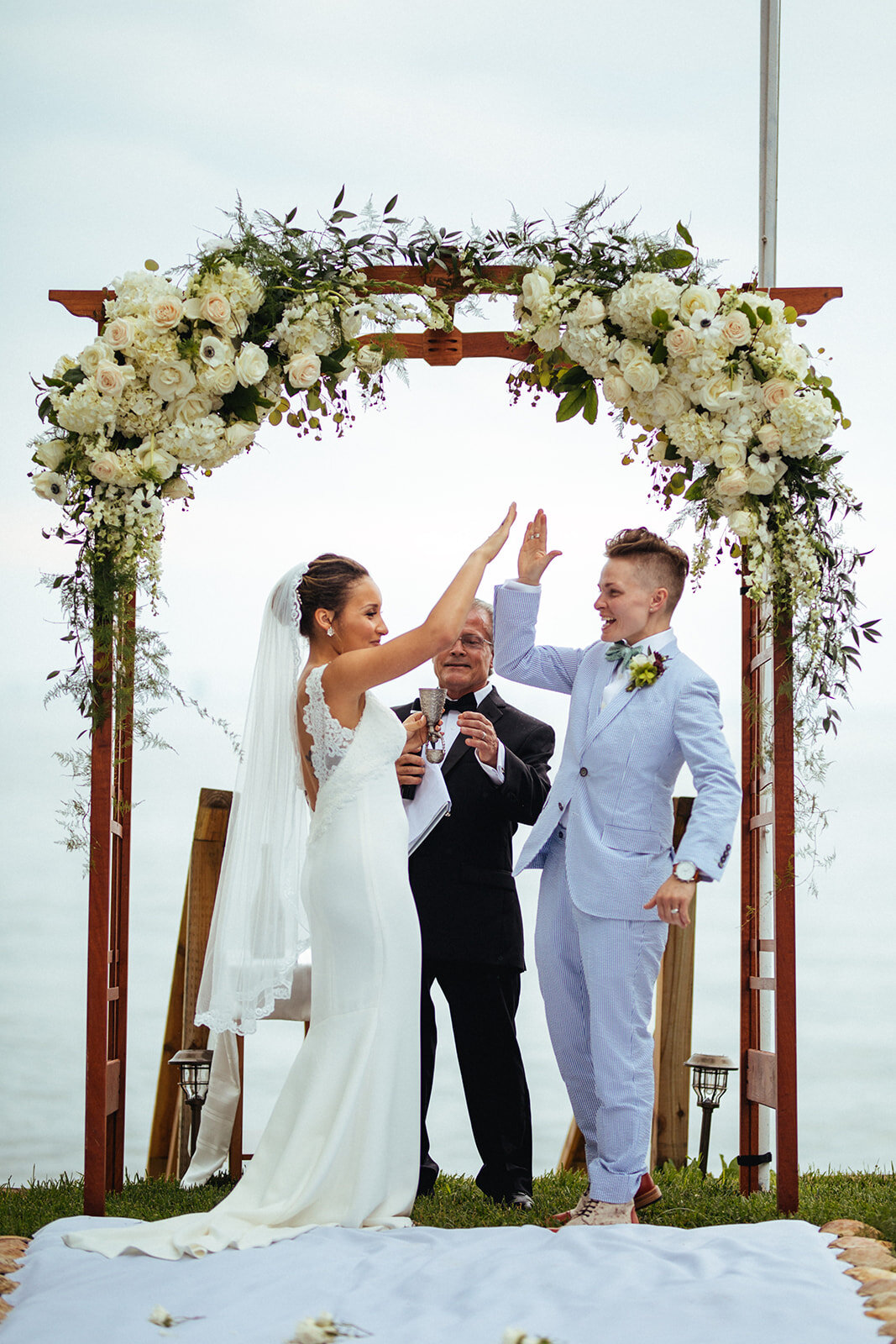 Newlyweds high fiving in Annapolis MD Shawnee Custalow Queer Wedding Photographer