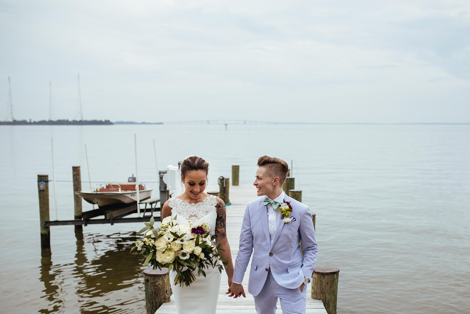 Newlyweds holding hands by the Chesapeake Bay in Annapolis MD Shawnee Custalow Photography