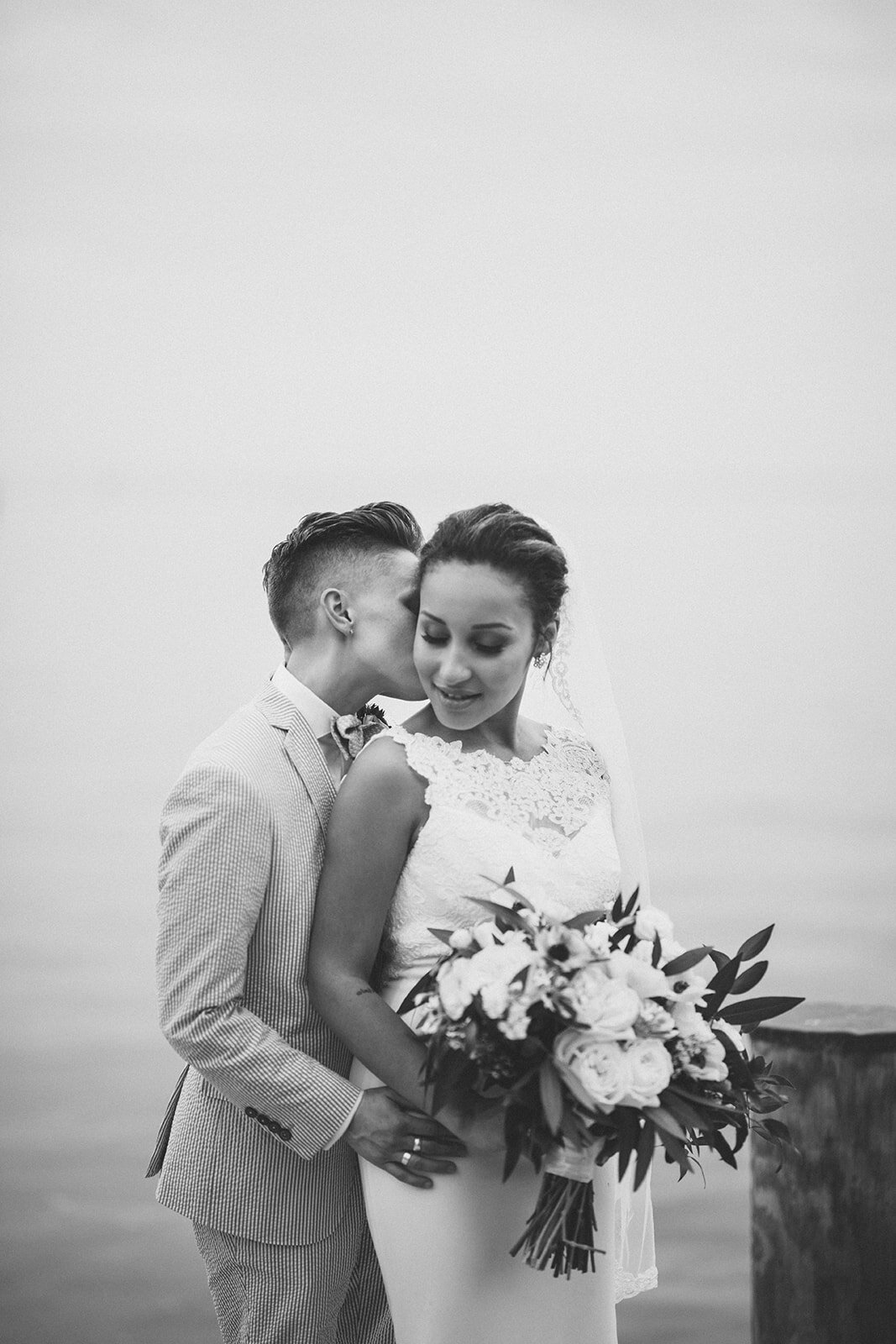 LGBTQ newlyweds embracing by the Chesapeake Bay in Annapolis MD Shawnee Custalow Photography