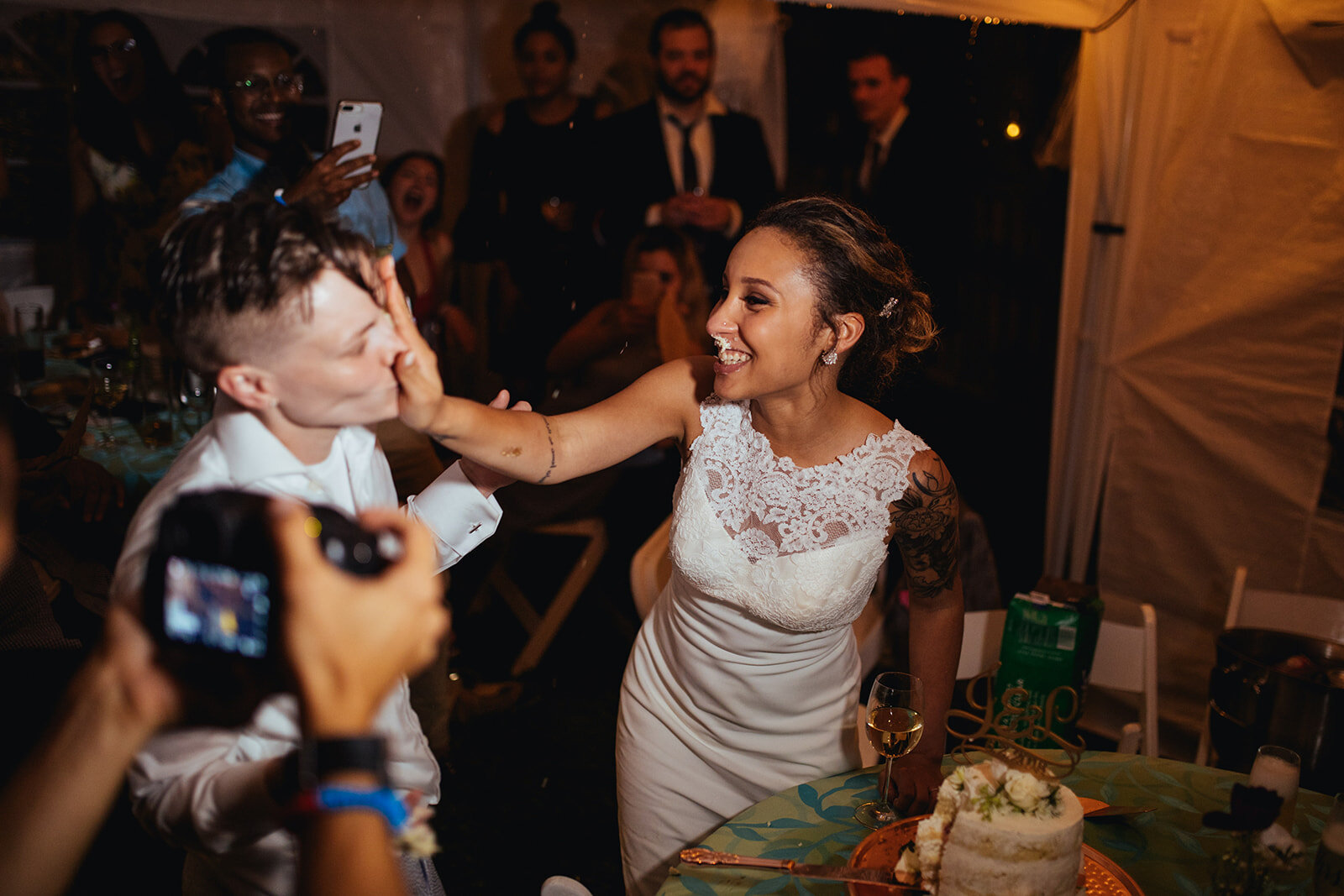 LGBTQ newlyweds feeding each other wedding cake in Annapolis MD Shawnee Custalow Photography