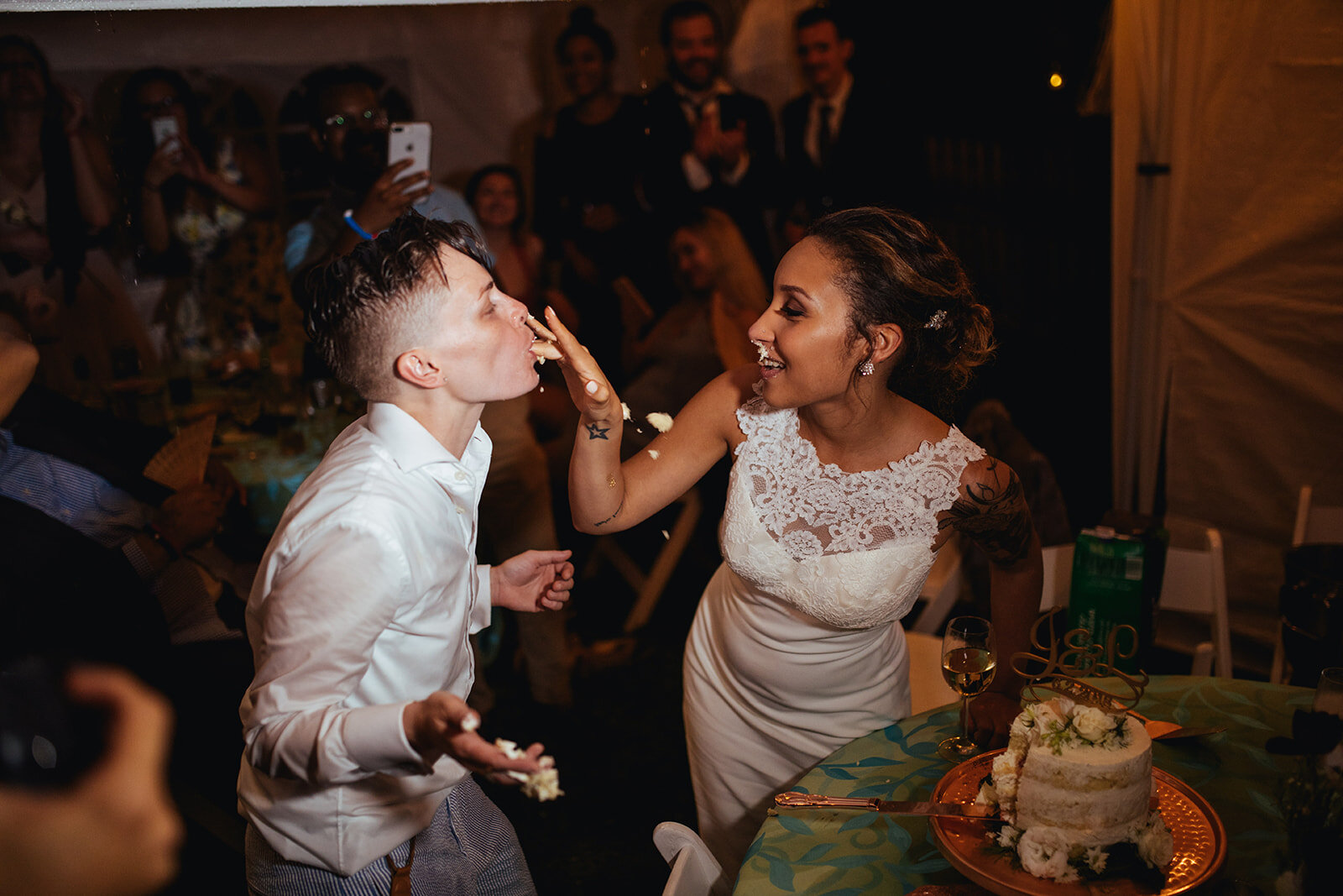 LGBTQ newlyweds feeding each other wedding cake in Annapolis MD Shawnee Custalow Photography