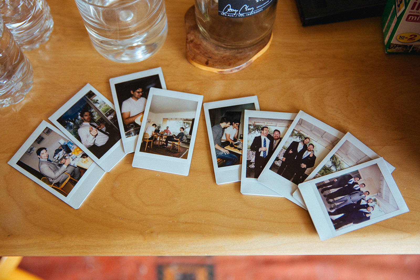 Polaroids of groomsmen laid out on a table in Studio City LA Shawnee Custalow Queer Wedding Photography