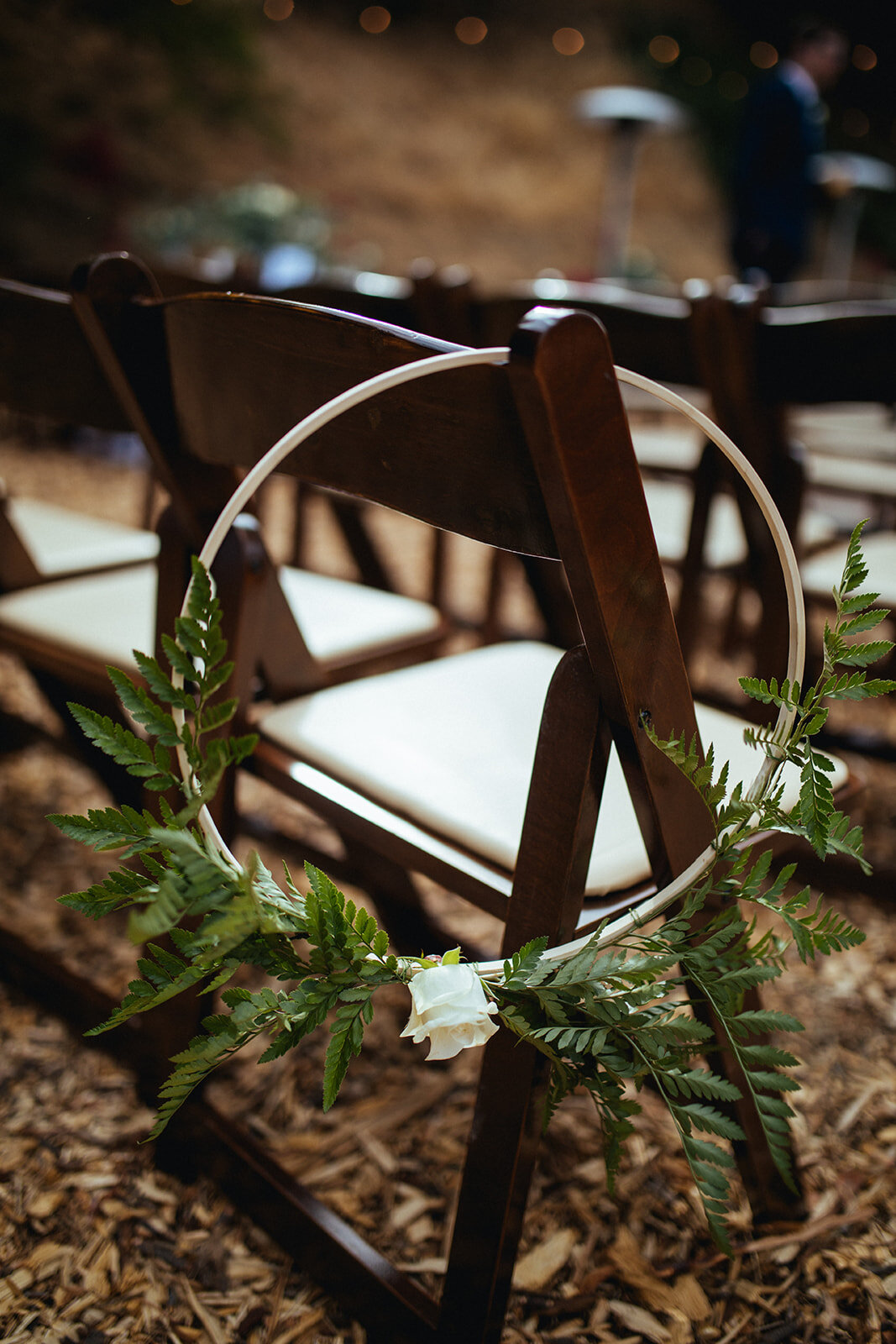 Floral ring garland hanging from chair set for wedding ceremony in LA Shawnee Custalow Queer Photography