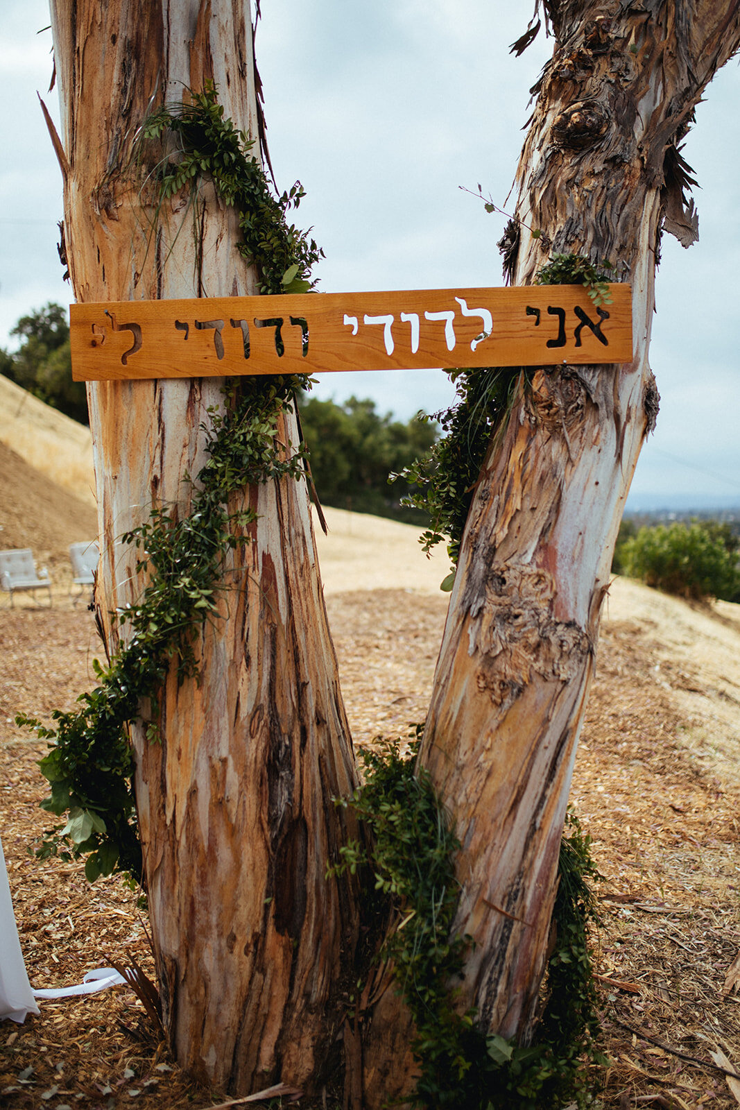 Wooden sign in hebrew decorating a backyard wedding in LA California Shawnee Custalow Photography