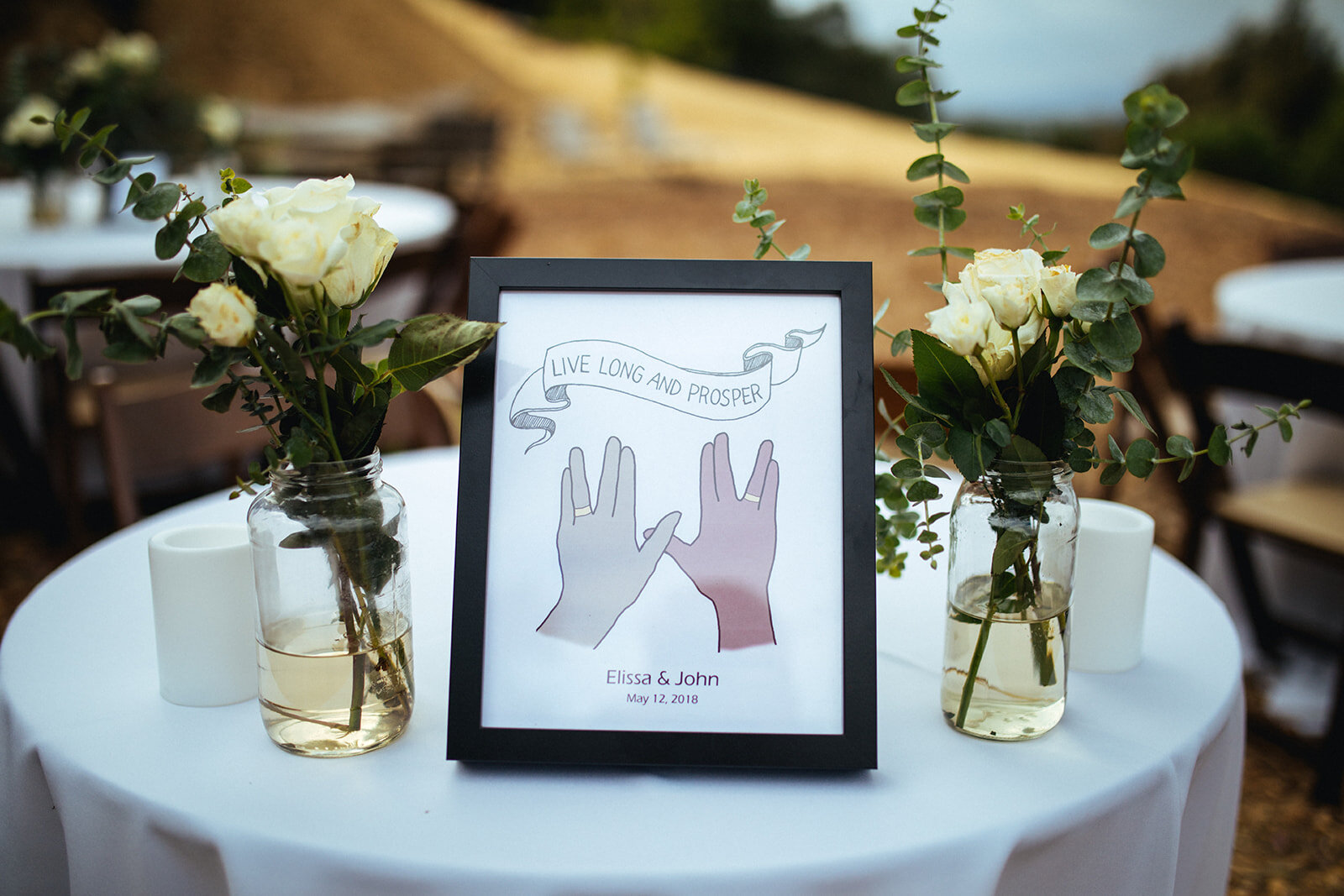 Table set with flowers candles and a sign referencing Star Trek in LA Shawnee Custalow Queer Wedding Photography