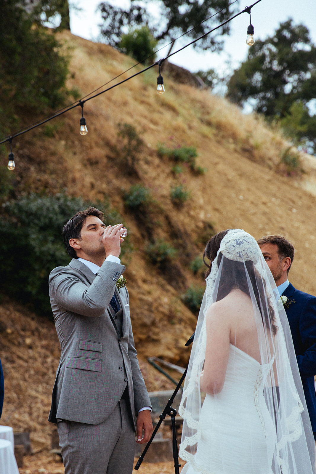 Groom drinking ritual wine at wedding ceremony in LA Shawnee Custalow Queer Wedding Photography