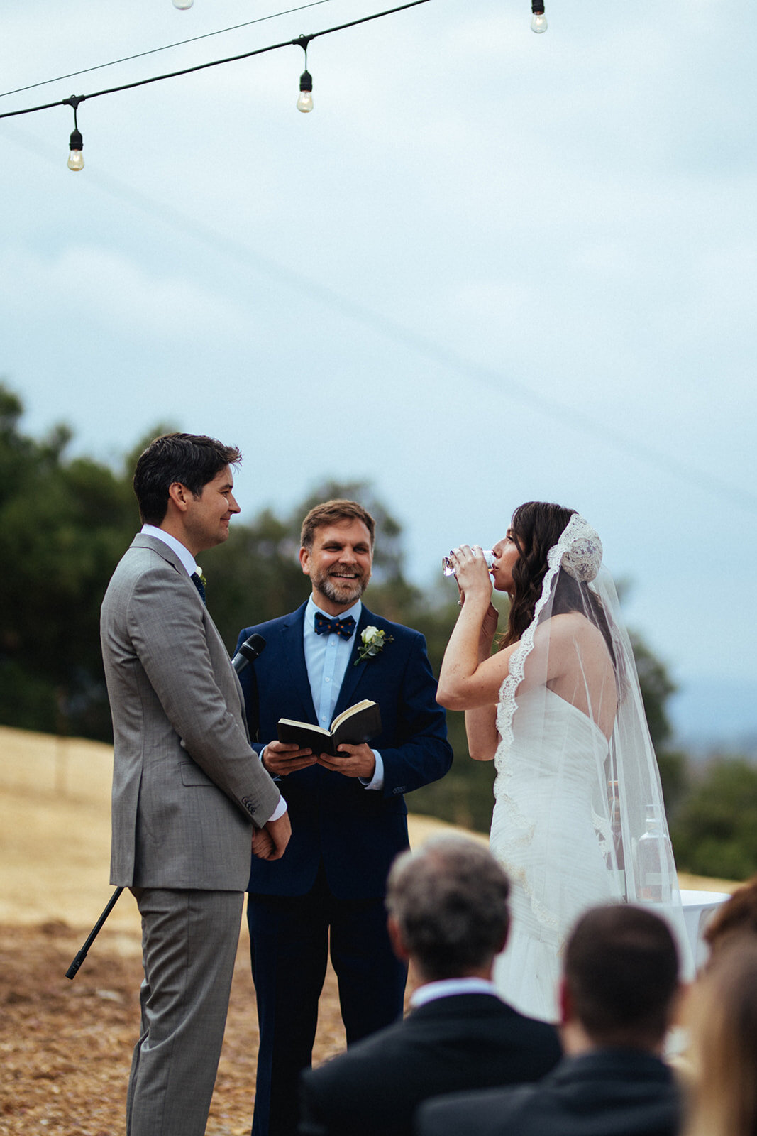 Bride drinking ritual wine at wedding ceremony in LA Shawnee Custalow Queer Wedding Photography