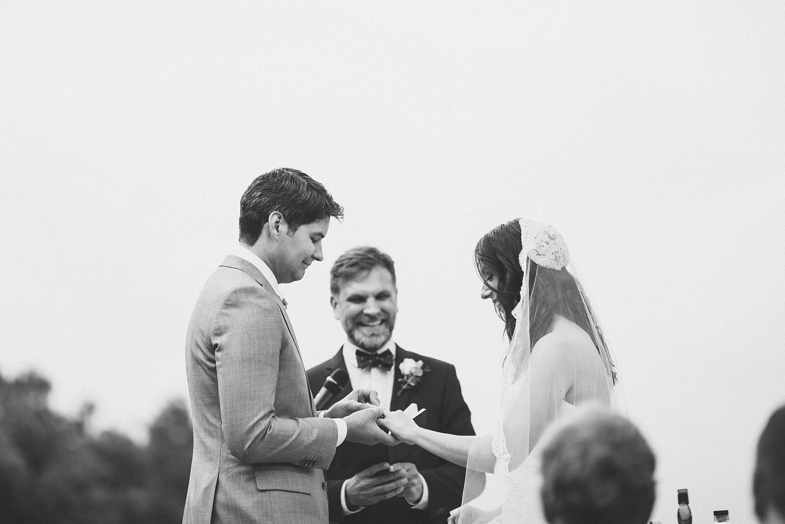 Bride and groom exchanging rings by officiant in Los Angeles Shawnee Custalow Queer Wedding Photography