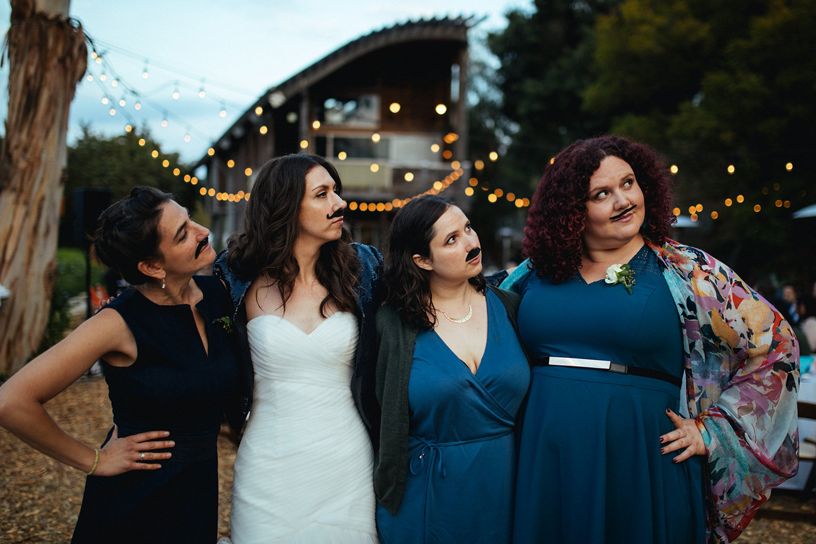 Bride and bridesmaids posing with faux mustaches in LA Shawnee Custalow Queer Wedding Photography