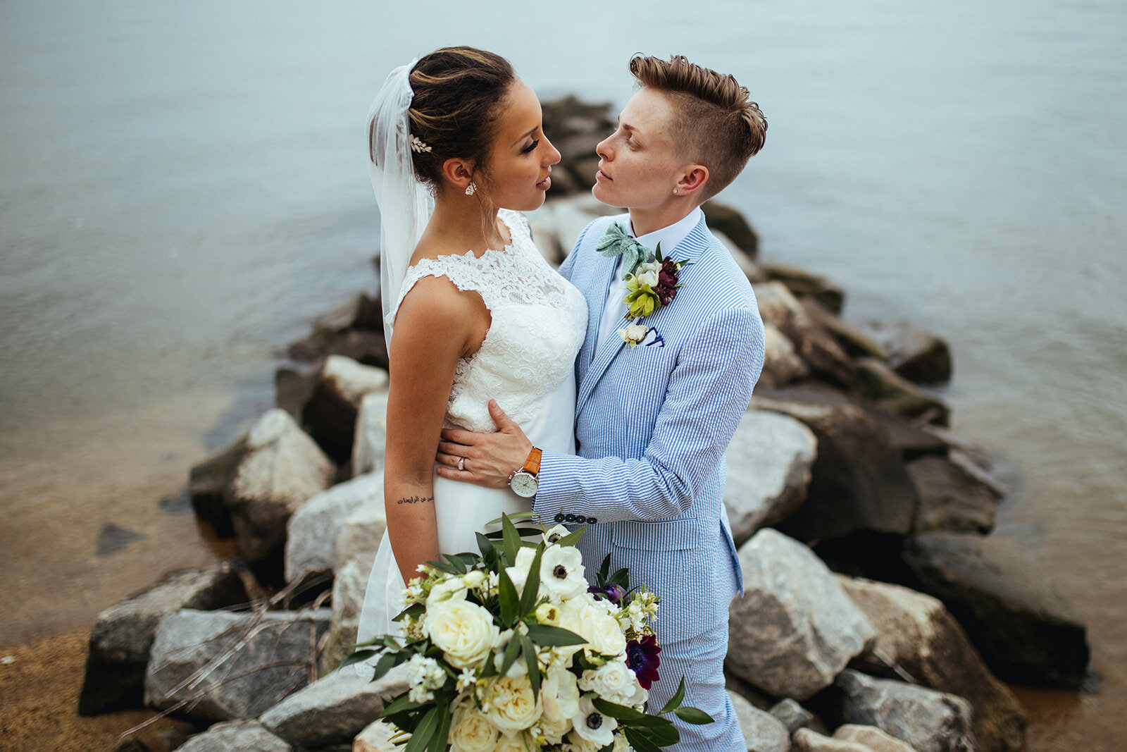 Queer newlyweds embracing by the Chesapeake Bay MD Shawnee Custalow Wedding Photography