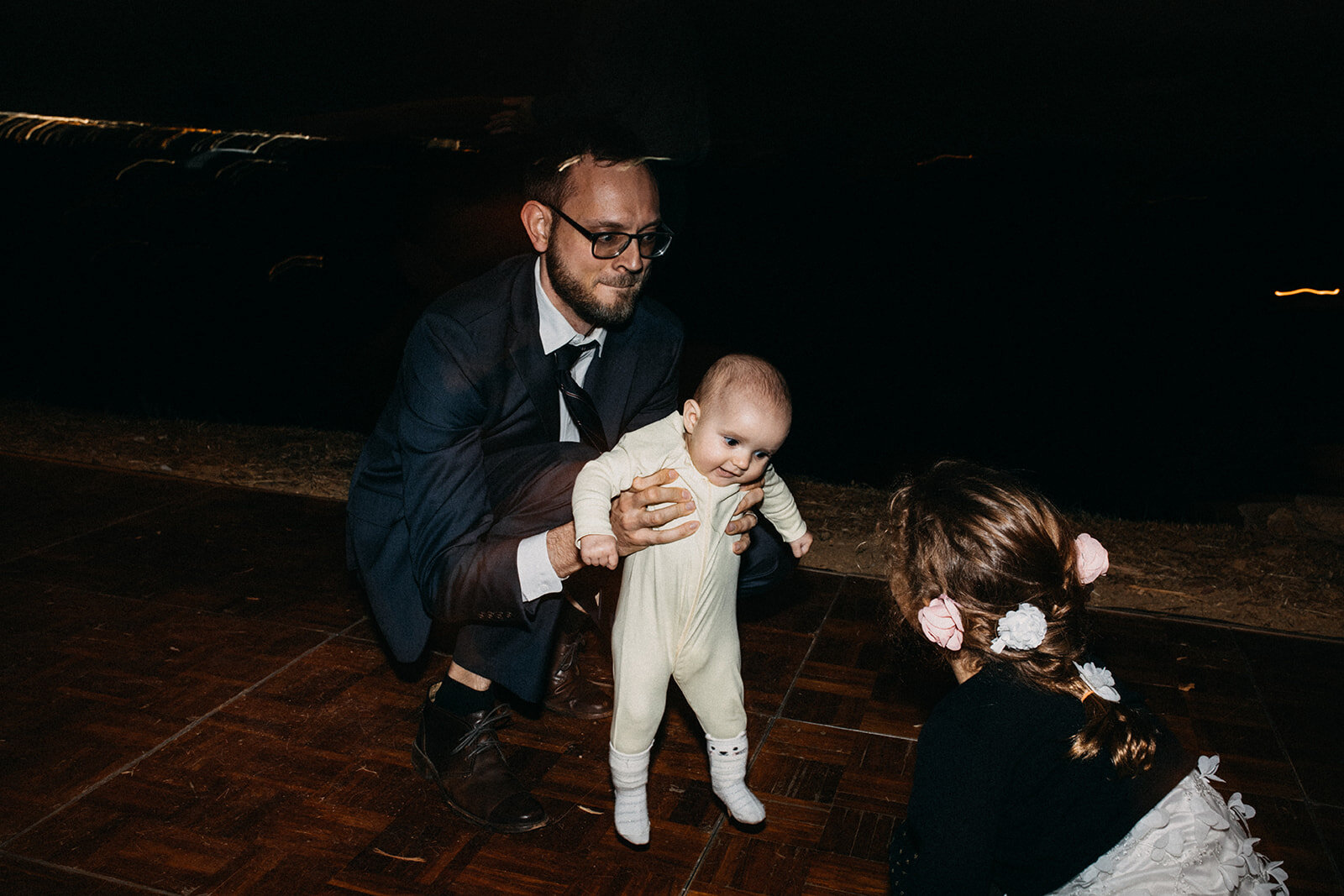 Wedding guest helping baby dance at reception in LA Wedding guests dancing at outdoor reception in LA Shawnee Custalow Queer Wedding Photography