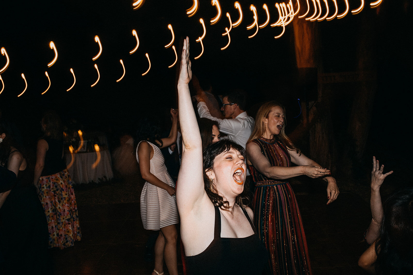 Wedding guests dancing at outdoor reception in LA Shawnee Custalow Queer Wedding Photography