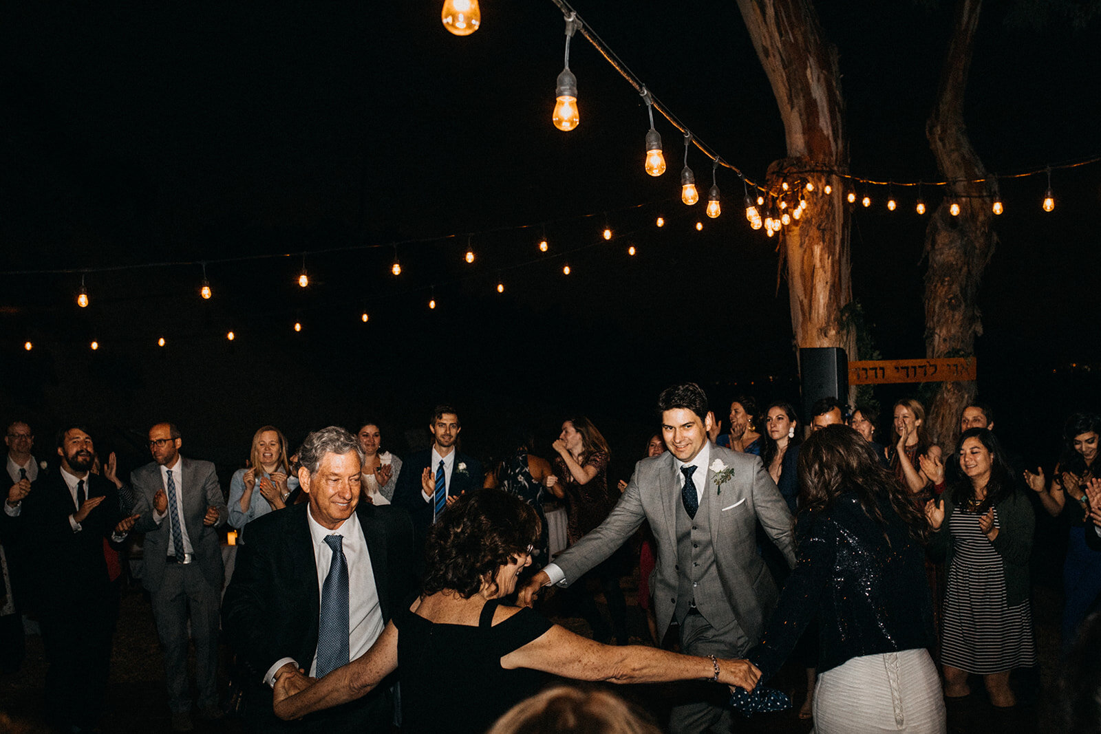 Groom dancing with bride and parents in a circle at LA reception Shawnee Custalow Queer Wedding Photography