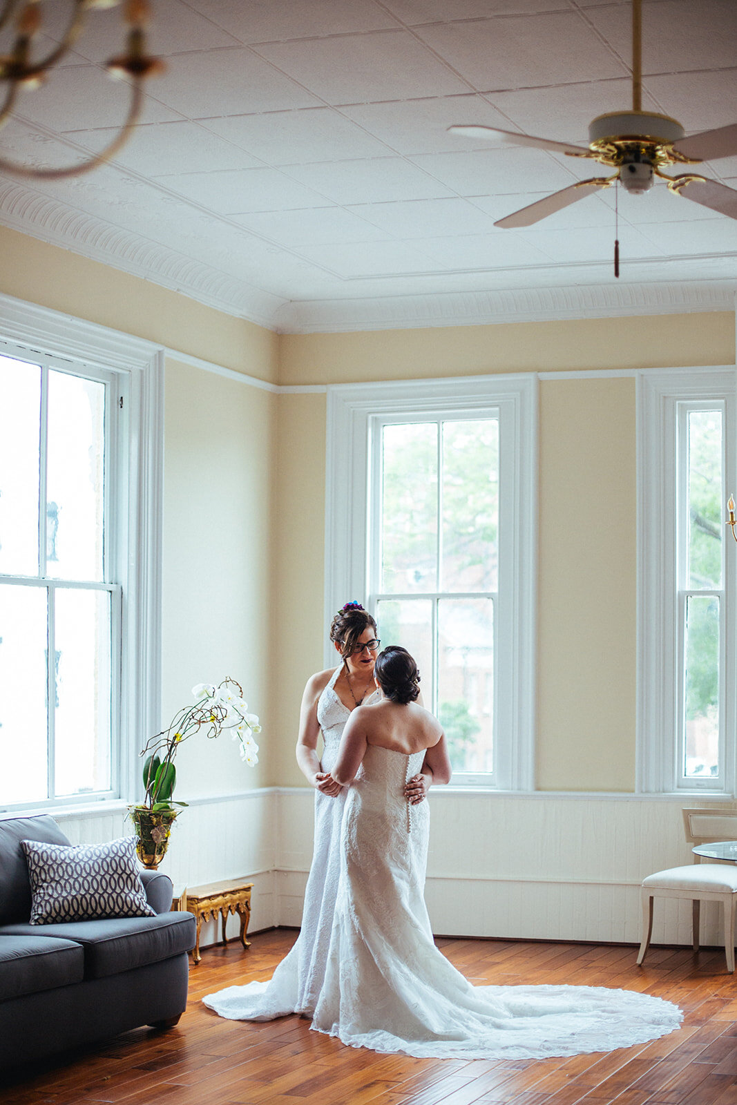 Two brides embracing before wedding at Torpedo Factory outside DC Shawnee Custalow Queer Wedding Photography