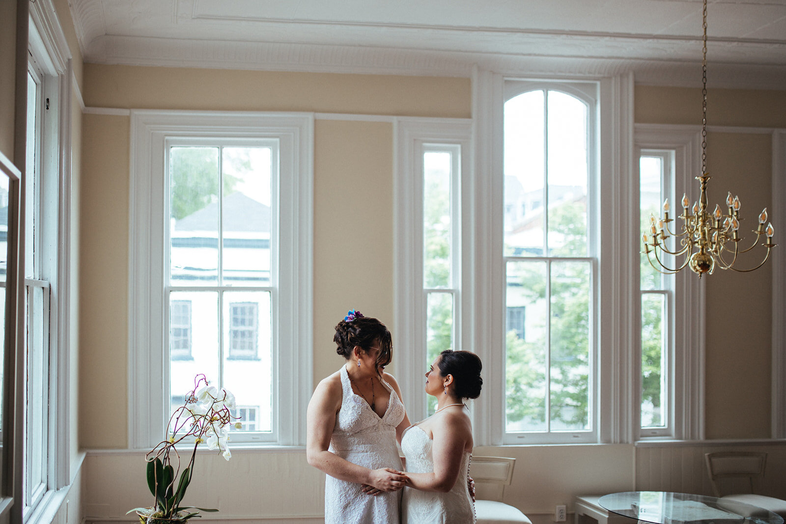 Two brides embracing before wedding at Torpedo Factory Alexandria VA Shawnee Custalow Queer Wedding Photography