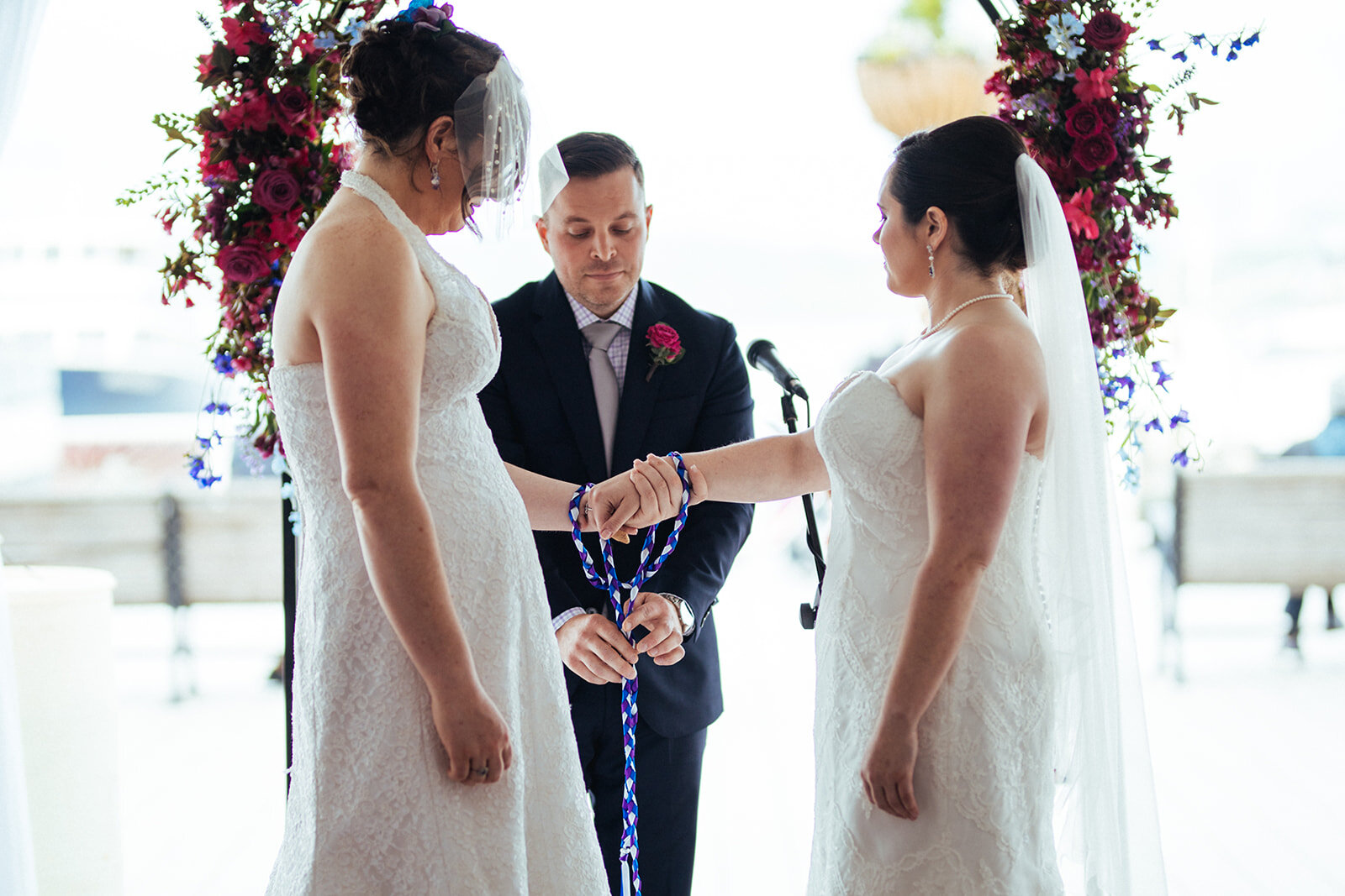 Two brides getting married with hand fasting ritual at Torpedo Factory Virginia Shawnee Custalow