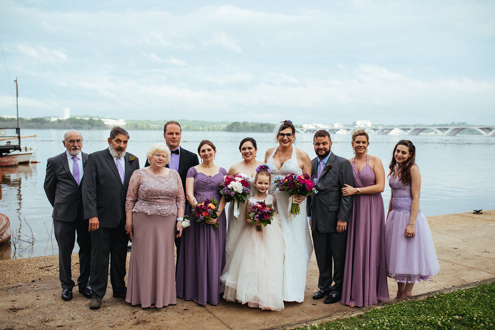 Married LGBTQ couple posing with family and friends in Alexandria VA Shawnee Custalow Queer Wedding Photographer