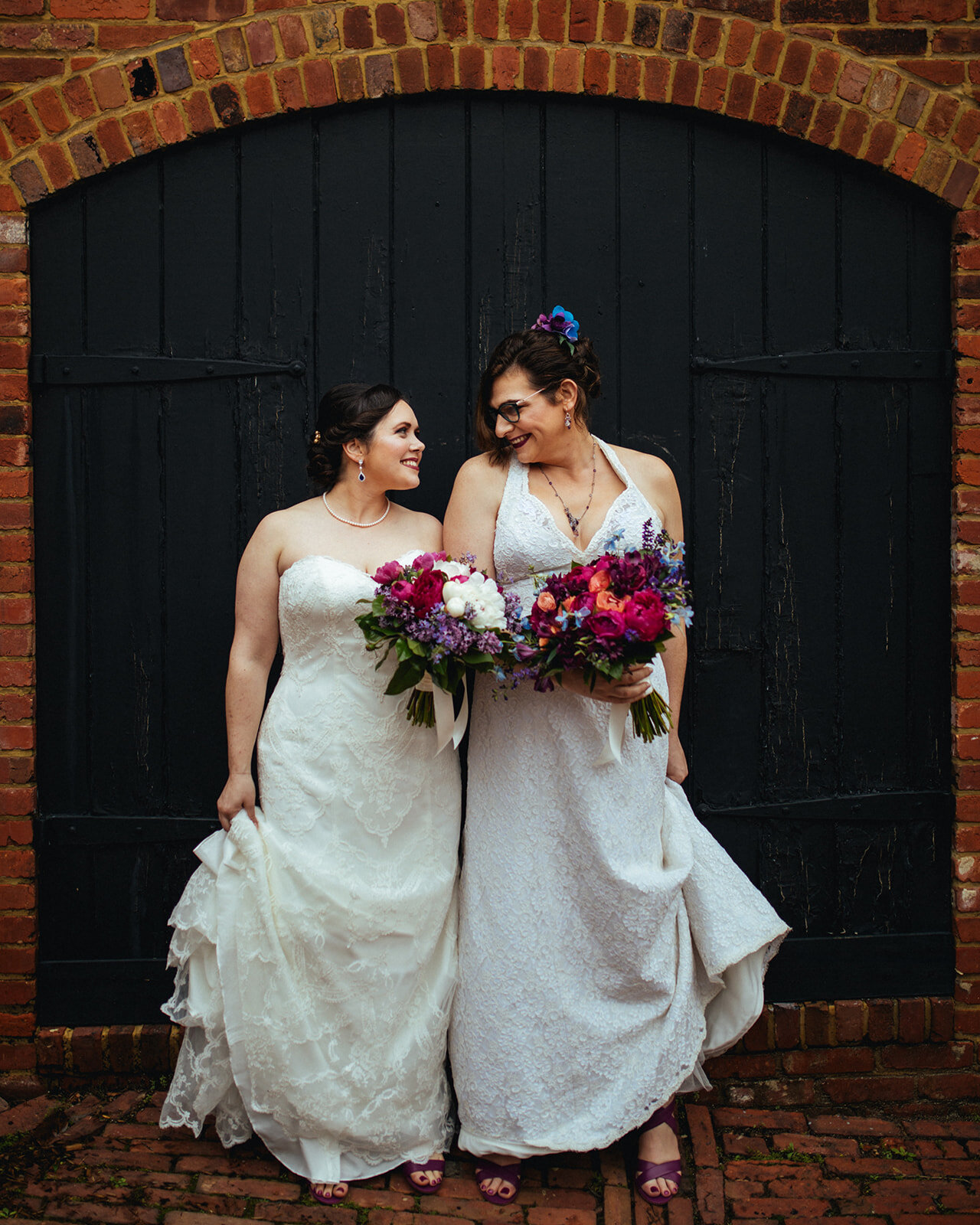 Newlywed brides smiling with bouquets in Alexandria VA Shawnee Custalow Queer Wedding Photographer