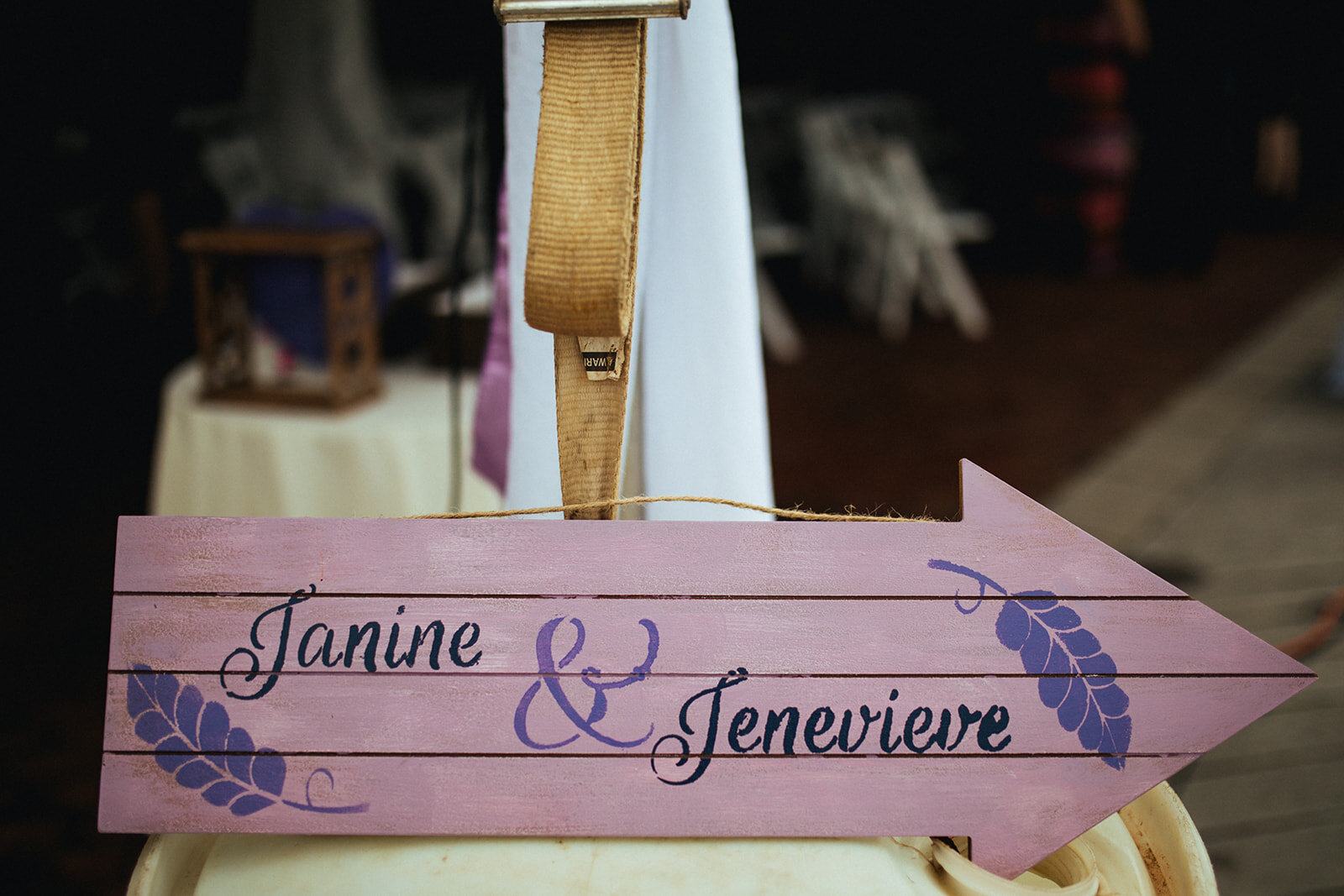 Wooden arrow with marrying couples names in Alexandria VA Shawnee Custalow Queer Wedding Photographer