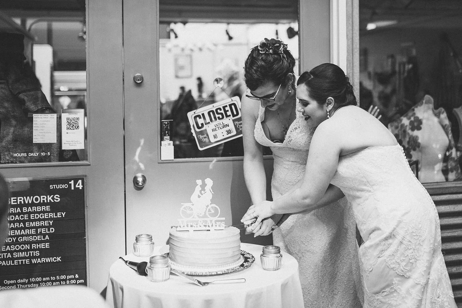 Newlyweds cutting the cake at Torpedo Factory Alexandria VA Shawnee Custalow Queer Wedding Photography