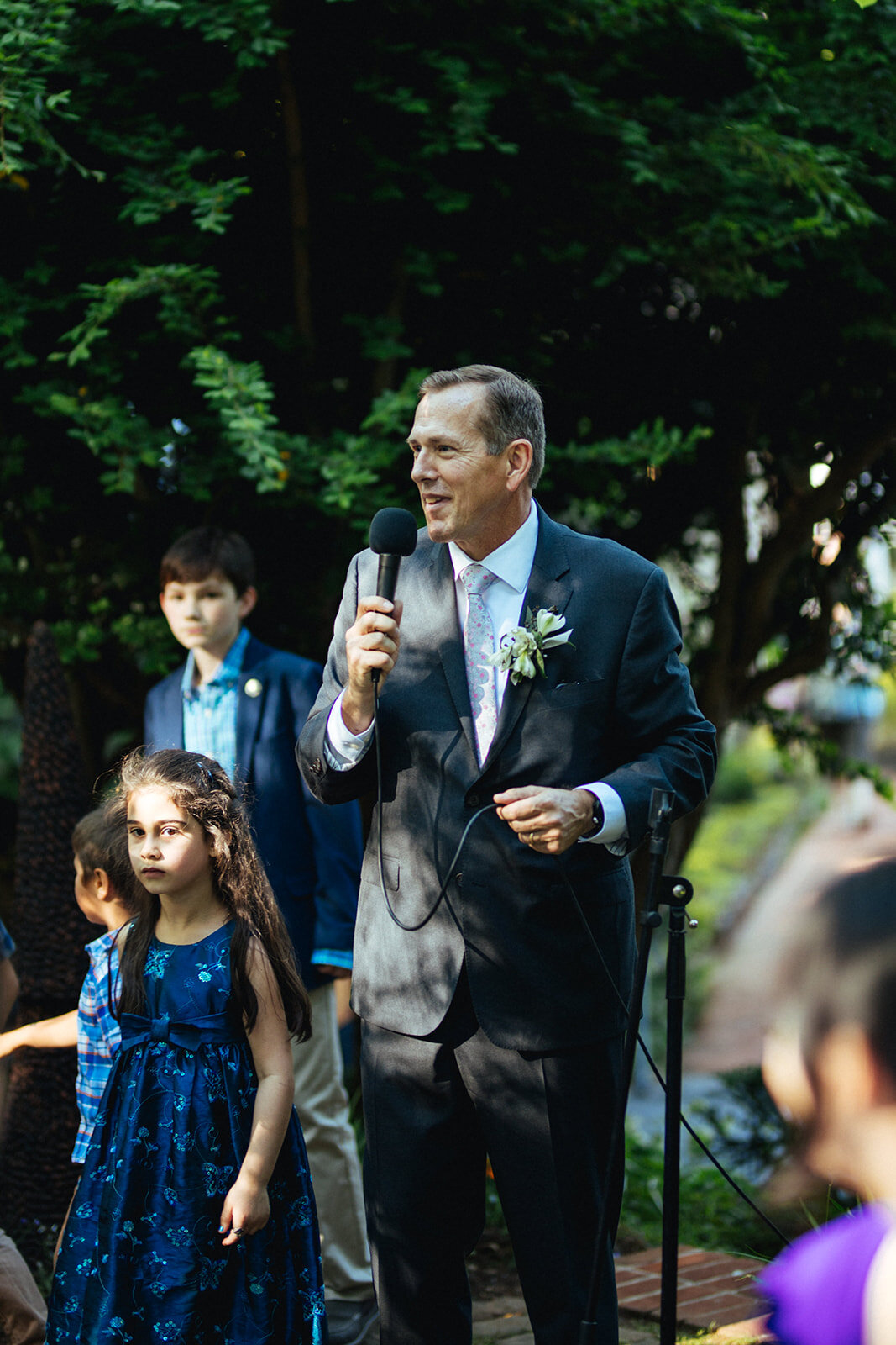 Guest giving a speech at a backyard wedding in ATL Shawnee Custalow Queer Wedding Photographer