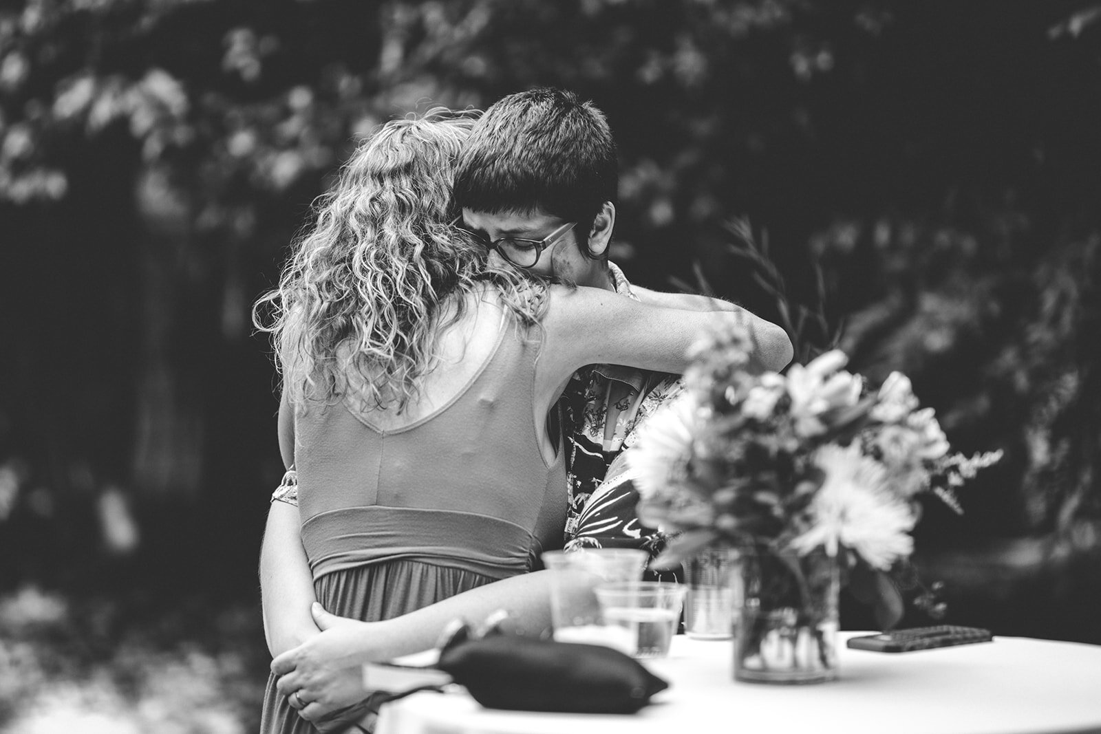 Two guests hugging at backyard Atlanta wedding Shawnee Custalow Queer Wedding Photographer