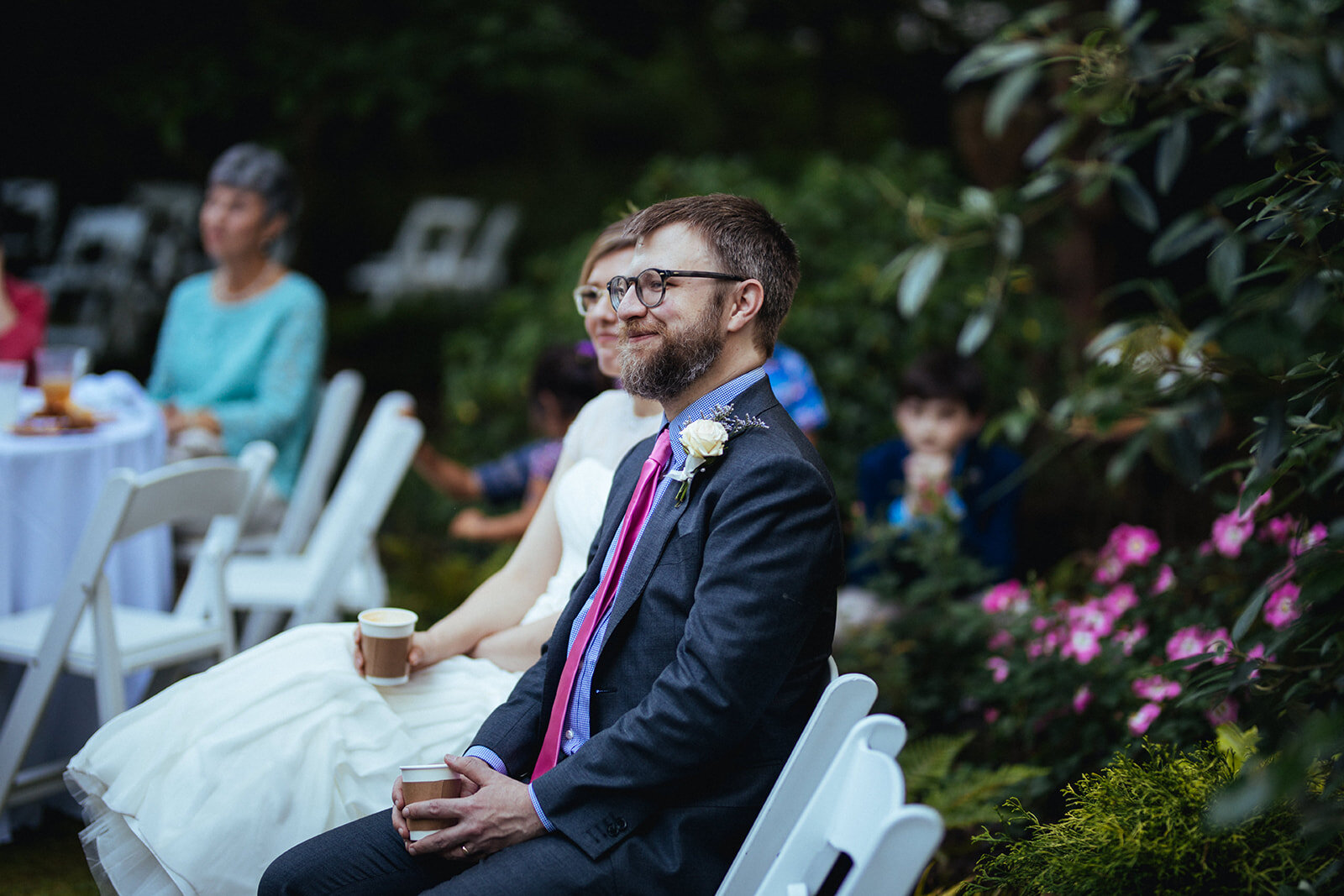 Bride and groom sitting at backyard reception in ATL Shawnee Custalow Queer Wedding Photographer