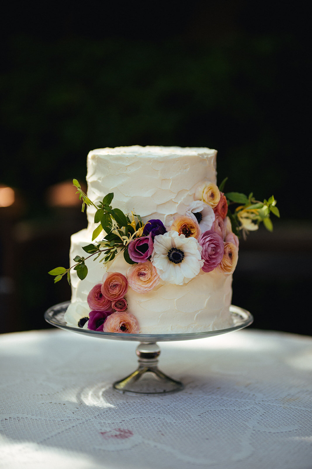 White wedding cake decorated with flowers in Atlanta GA Shawnee Custalow Queer Wedding Photographer
