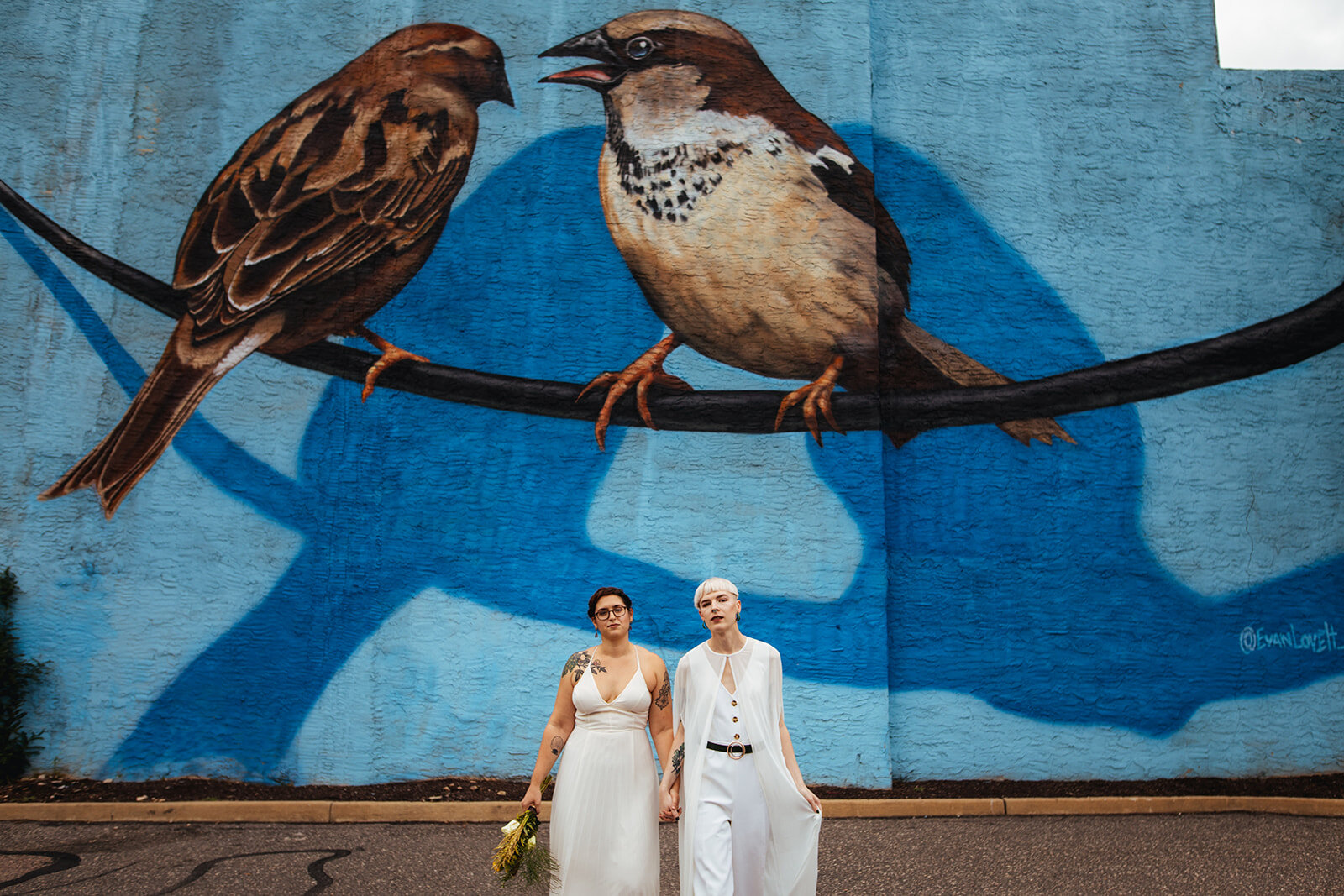 LGBTQ couple holding hands in front of a mural in Philly PA Shawnee Custalow Wedding Photography