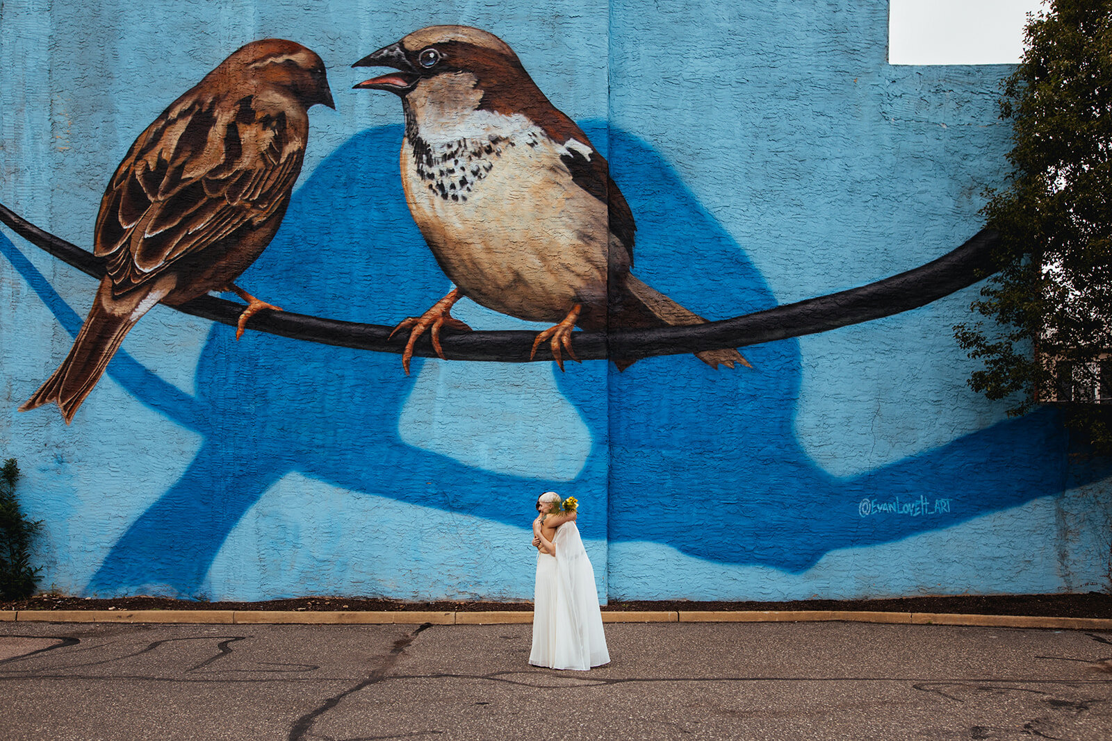 Future spouses hugging under a girl mural in Philadelphia Shawnee Custalow Photography