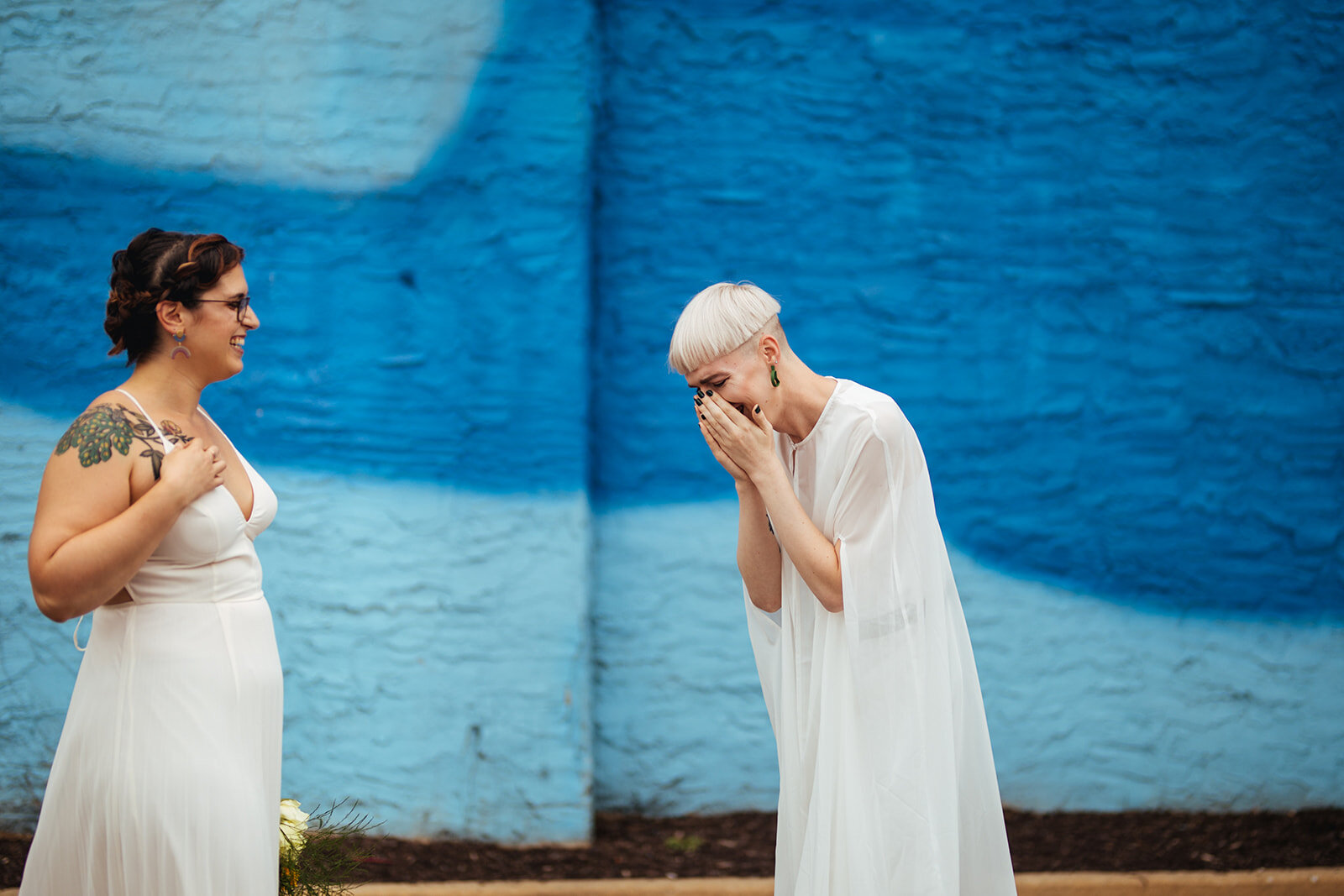 LGBTQ future spouses laughing by a mural in Philadelphia PA Shawnee Custalow Photography