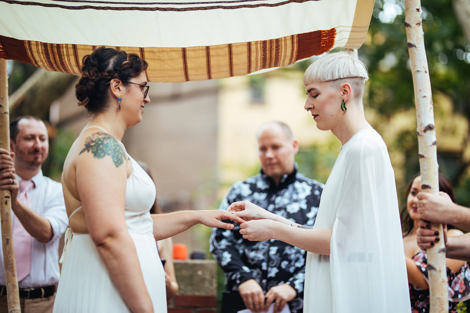 LGBTQ couple exchanging rings under a chuppah in Philly Shawnee Custalow Queer Wedding photography