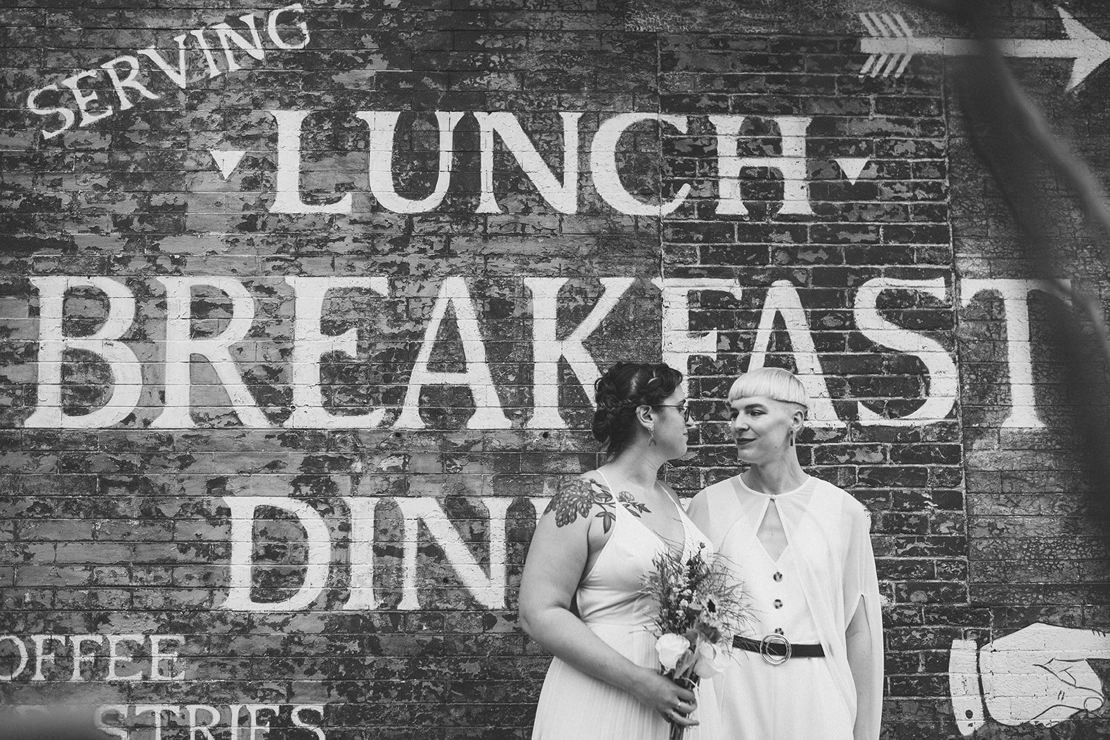 Happy LGBTQ newlyweds outside Philly restaurant Shawnee Custalow Queer Wedding photography