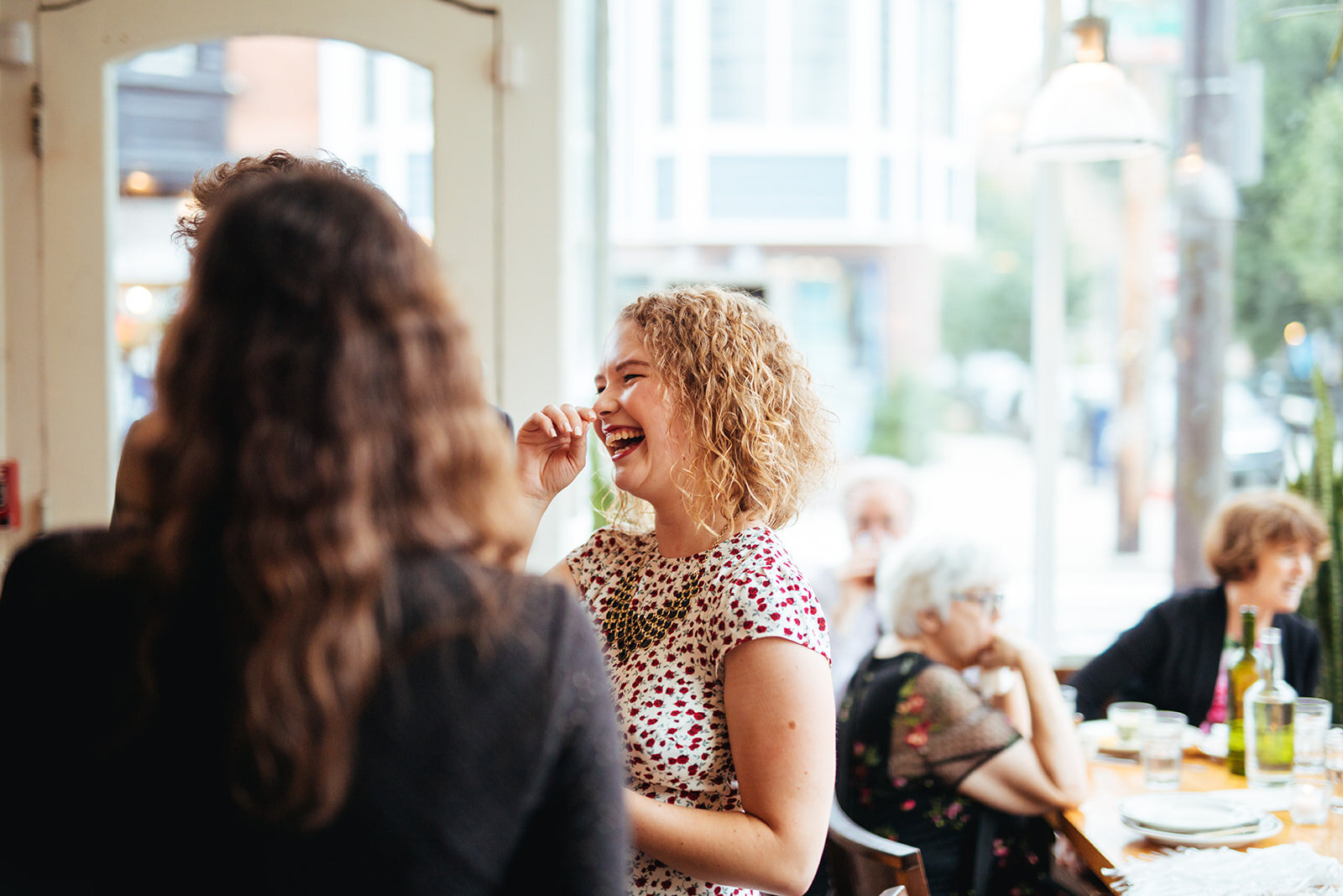 Wedding guest laughing at reception in Philadelphia PA Shawnee Custalow Queer Wedding photography