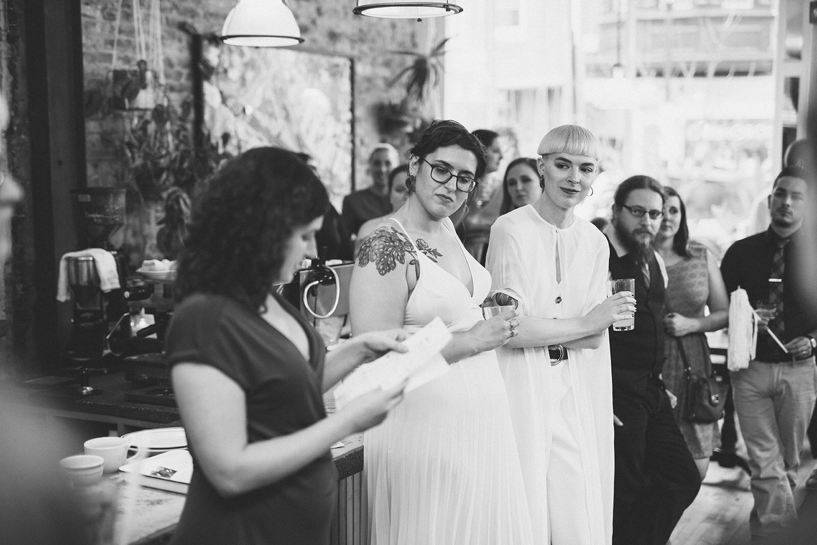 Newlyweds listening to a guests speech at reception in Philly Shawnee Custalow Queer Wedding photography