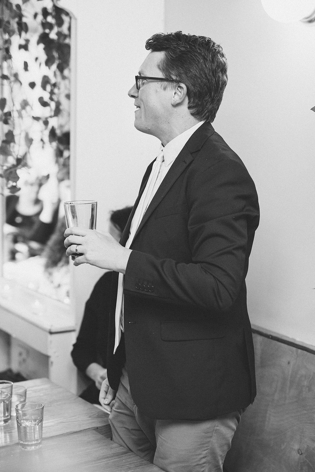Wedding guest with a glass at reception in Philadelphia PA Shawnee Custalow Queer Wedding photography