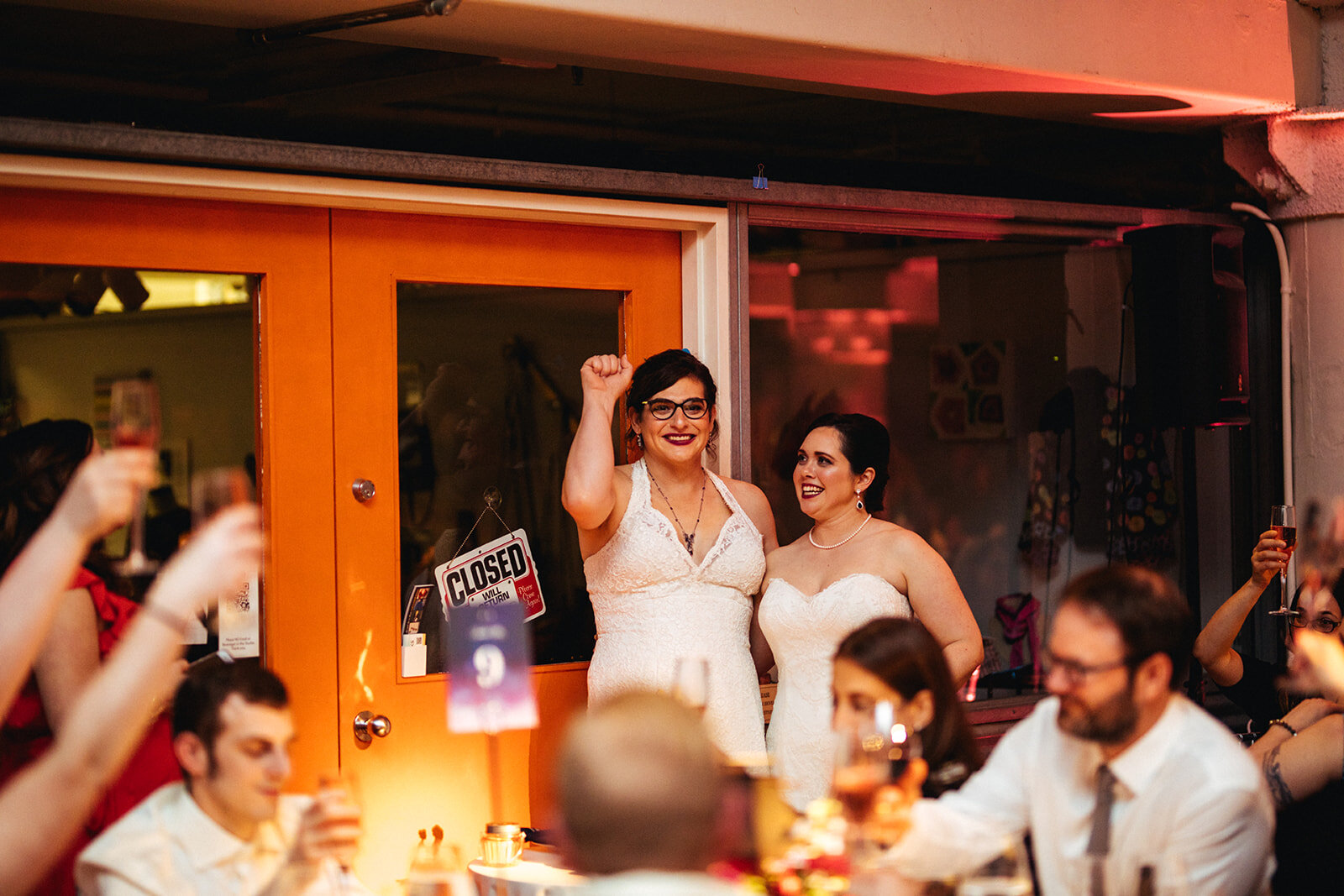 LGBTQ newlyweds fist pumping at Torpedo Factory Alexandria VA Shawnee Custalow Photography