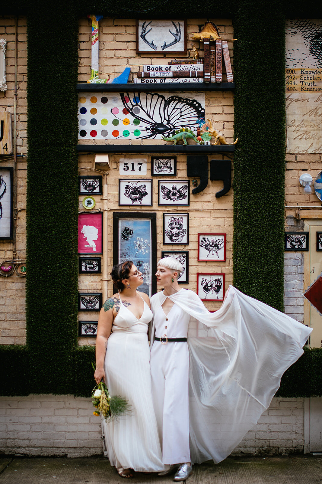 Wedding couple with cape by public art in Philly Shawnee Custalow Queer Wedding Photography