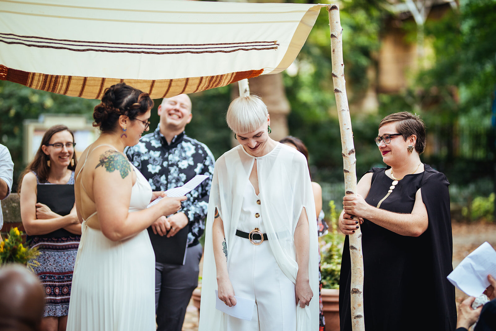 LGBTQ couple reading vows under a chuppah in Philly Shawnee Custalow Queer Wedding photography