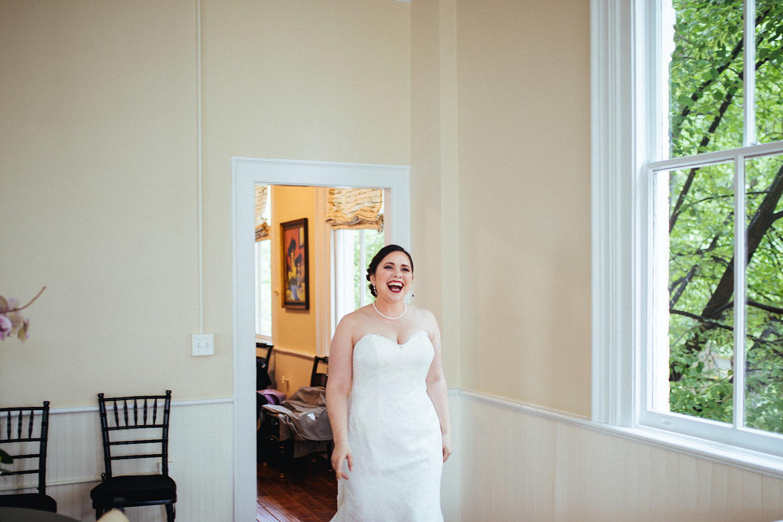 Bride entering a room smiling at Torpedo Factory Alexandria VA Shawnee Custalow Queer Wedding Photography