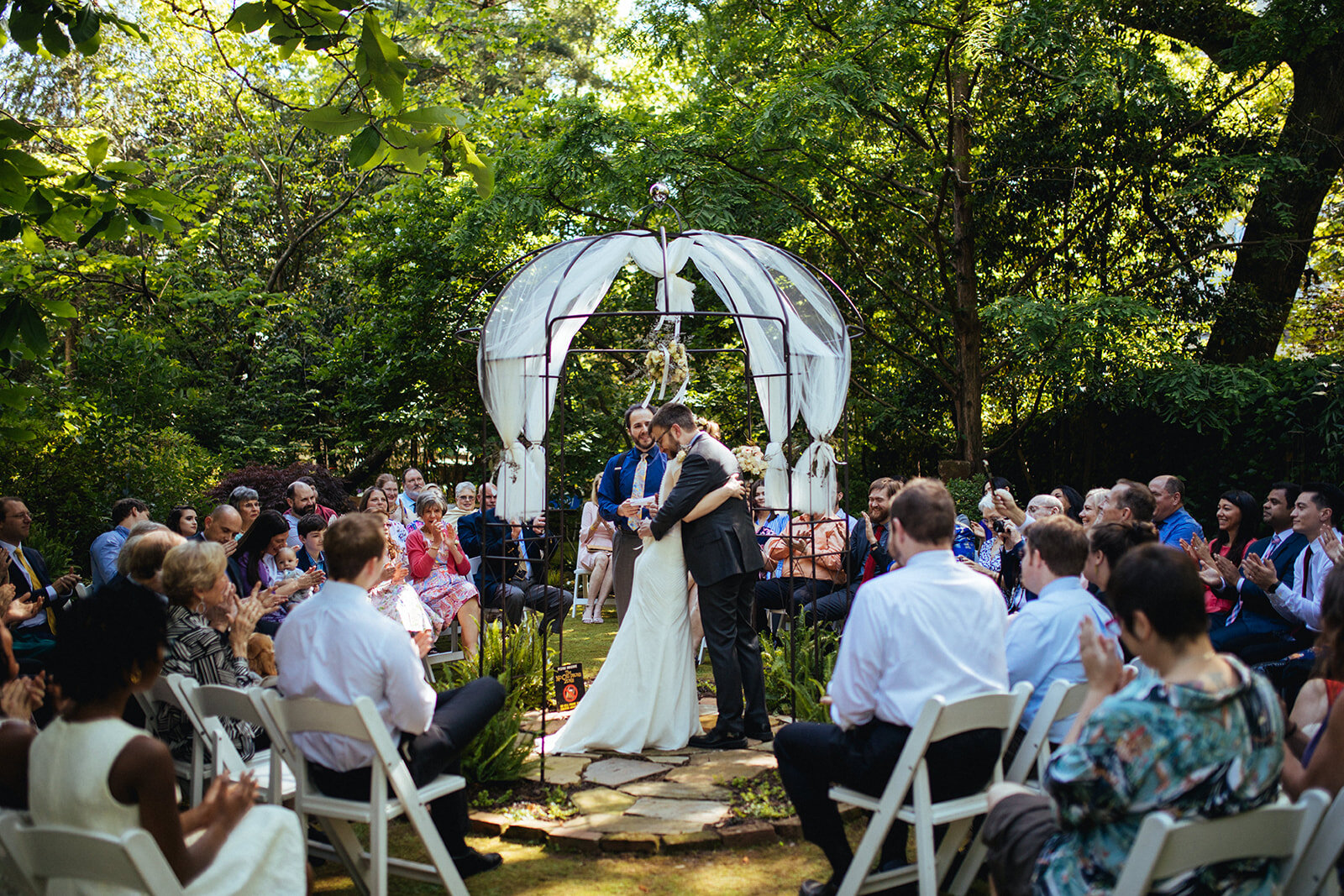 Marrying couple embracing at backyard ceremony in Atlanta GA Shawnee Custalow Queer Wedding Photographer