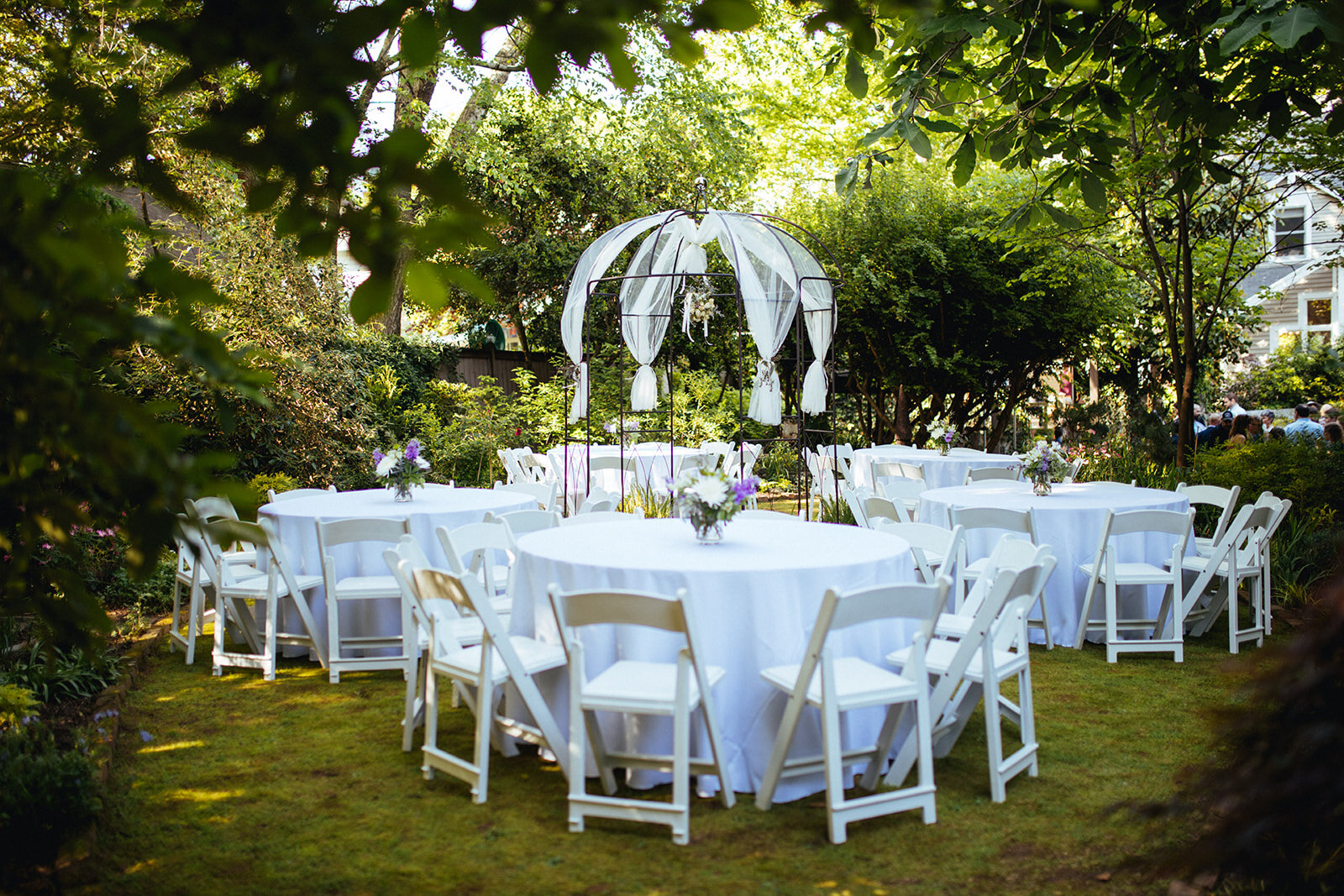 Backyard set with round white tables for reception in Atlanta GA Shawnee Custalow Queer Wedding Photographer