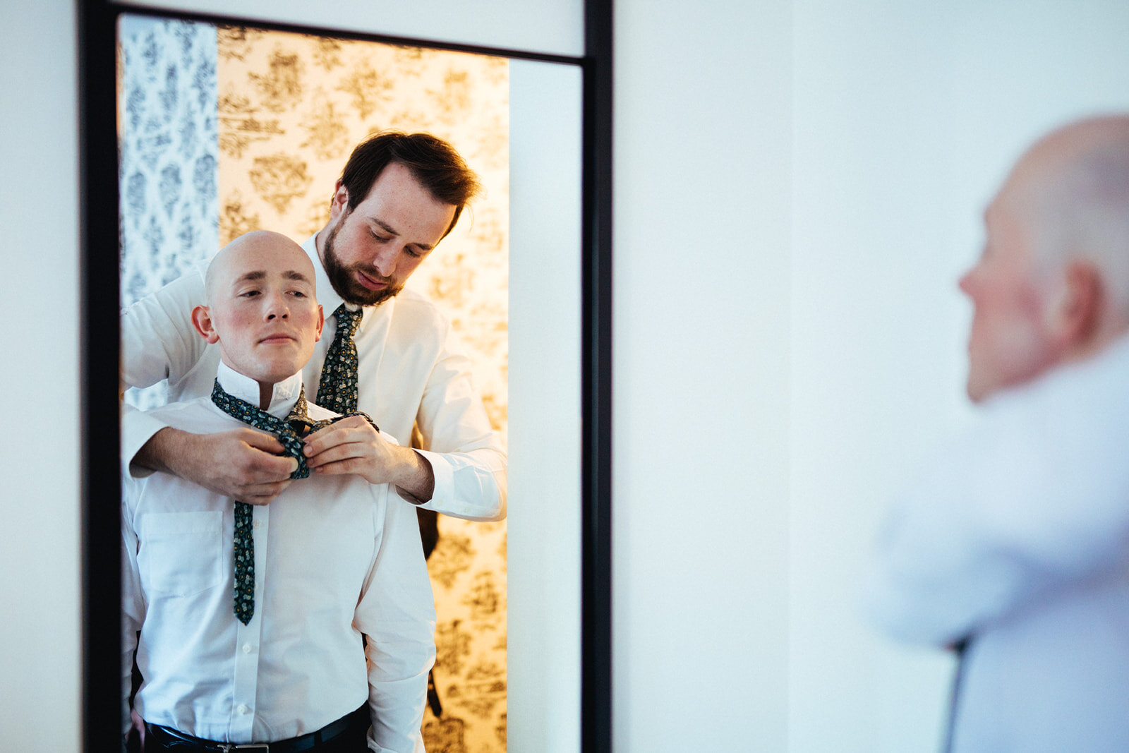 Groomsmen helping each other with their ties in Brooklyn NY Shawnee Custalow wedding photography